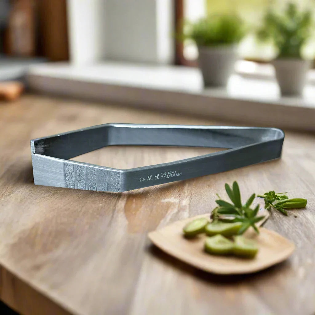 Learn why fish bone tweezers are essential for precision deboning, shown against a wooden surface with herbs.