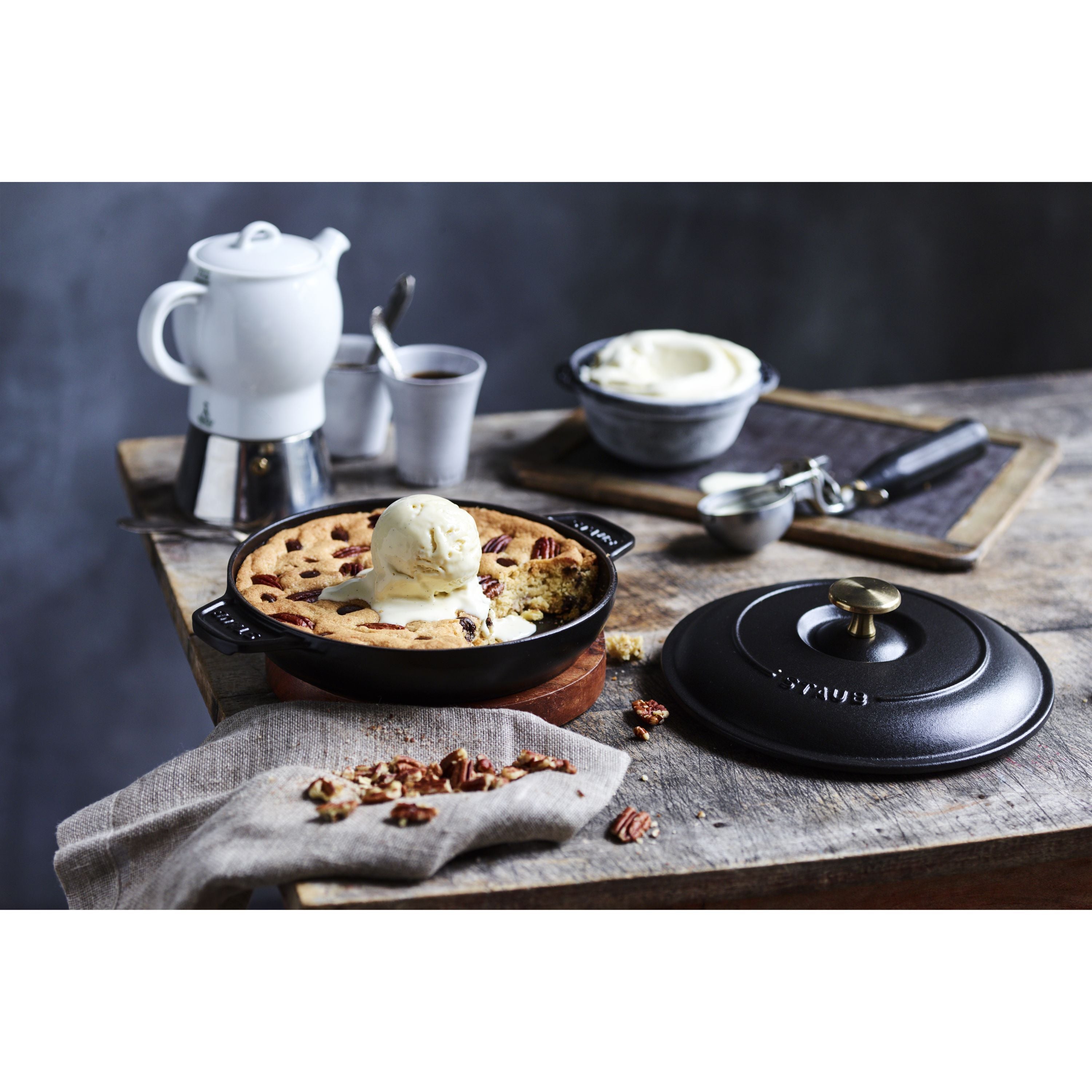 STAUB Specialities 750 ml Cast Iron Round Oven Dish with lid, black, filled with dessert and served with ice cream.