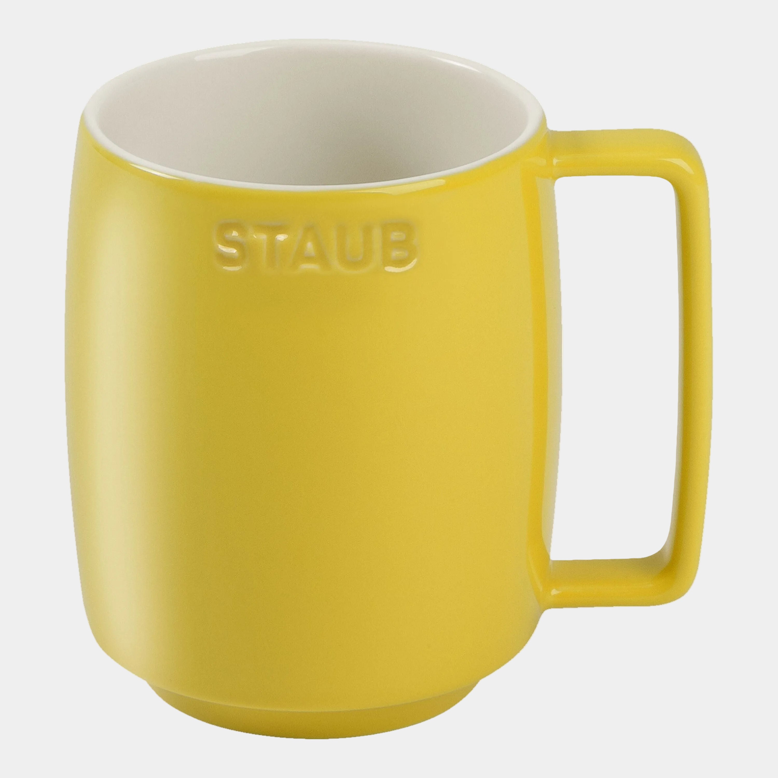 Yellow mug with white interior on a white background, featuring the Staub logo.