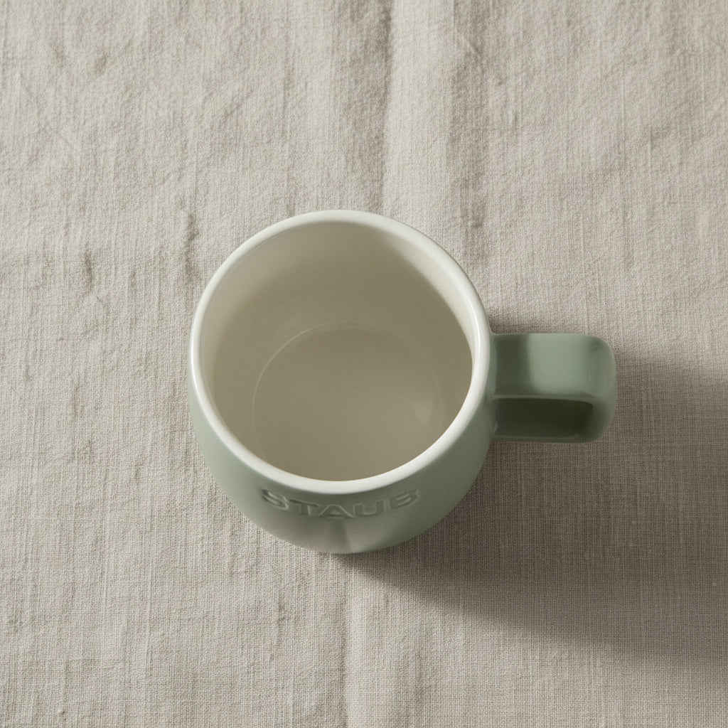 Green mug with 'Staub' branding on a white background