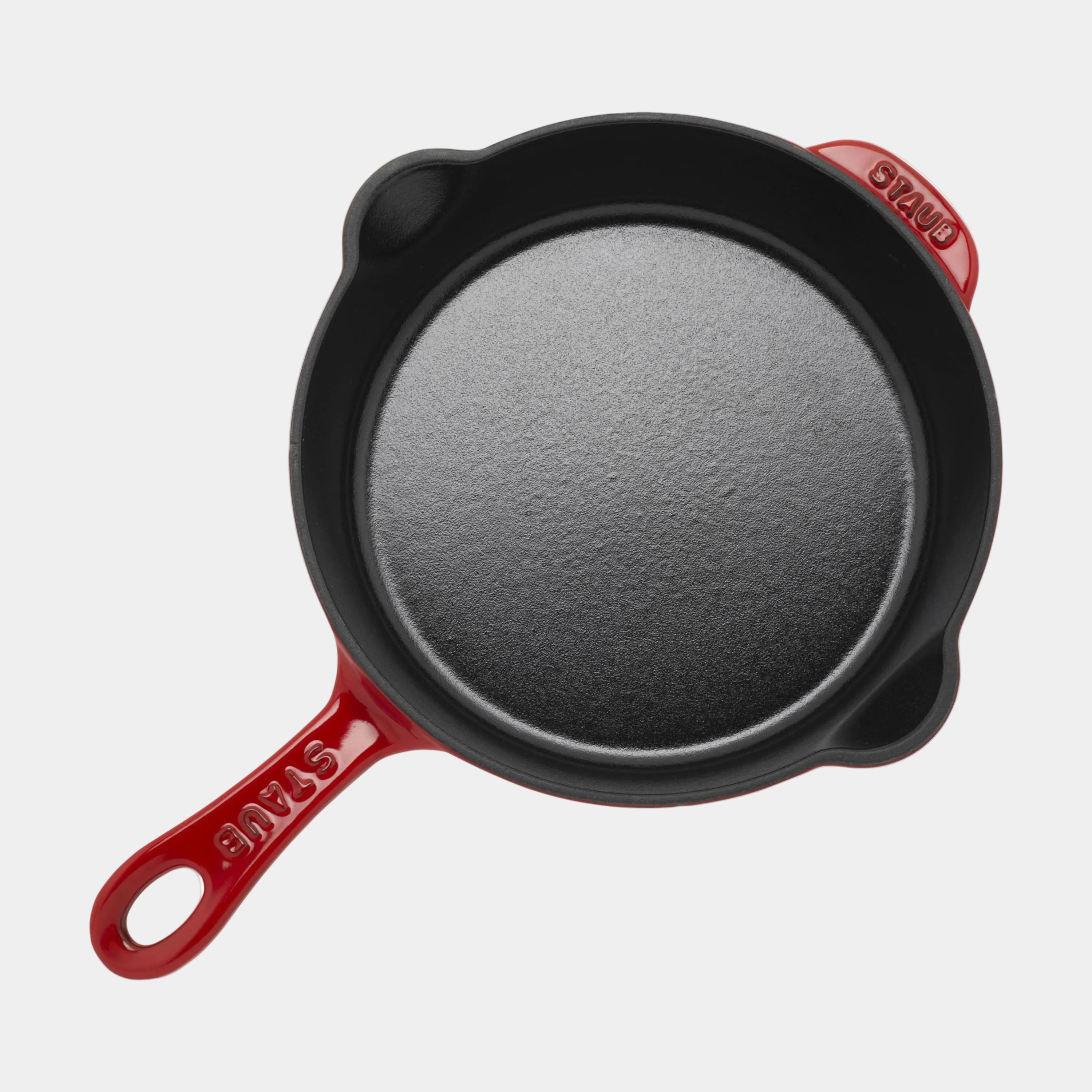 Red-handled cast iron skillet on a white background