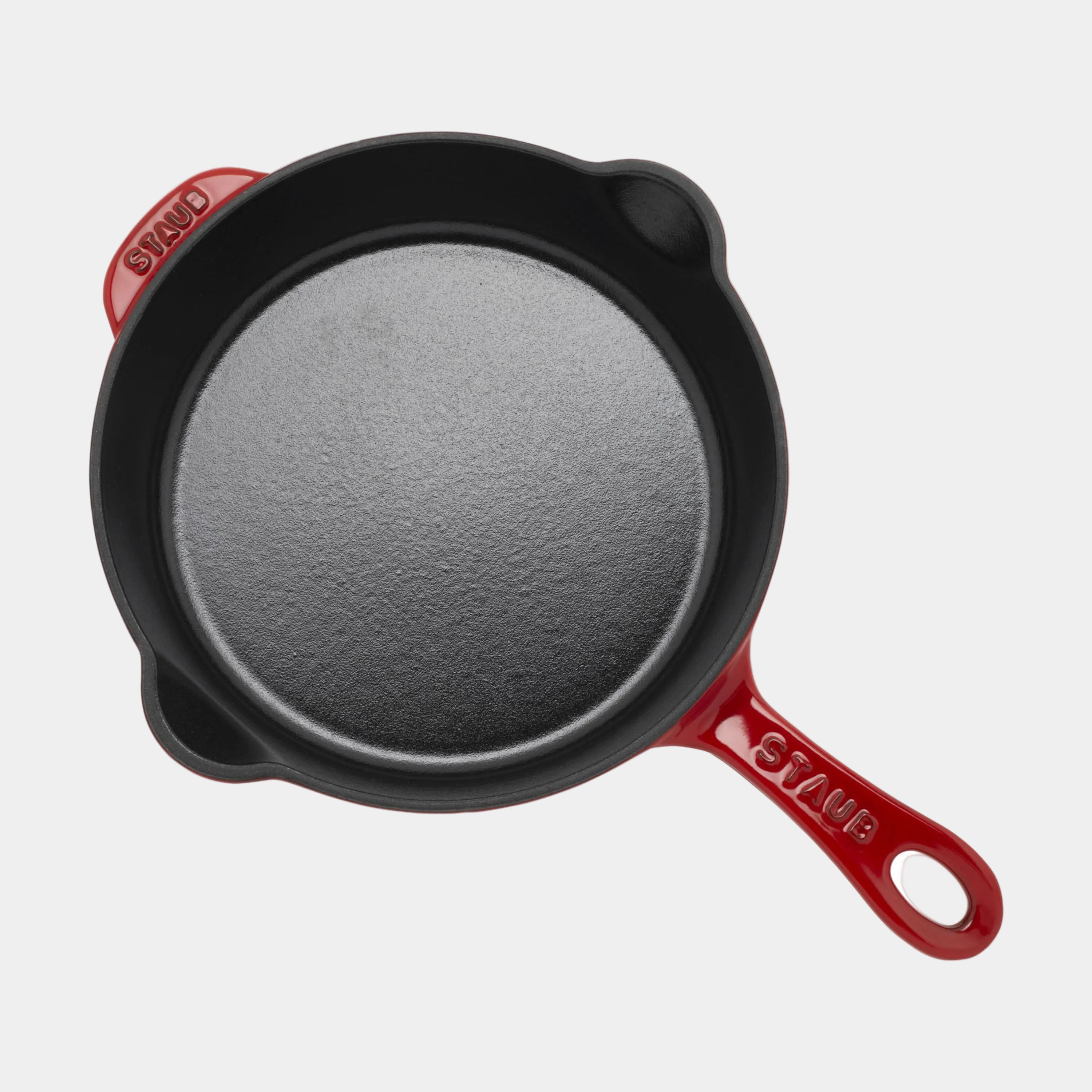 Black cast iron skillet with red handle on a white background
