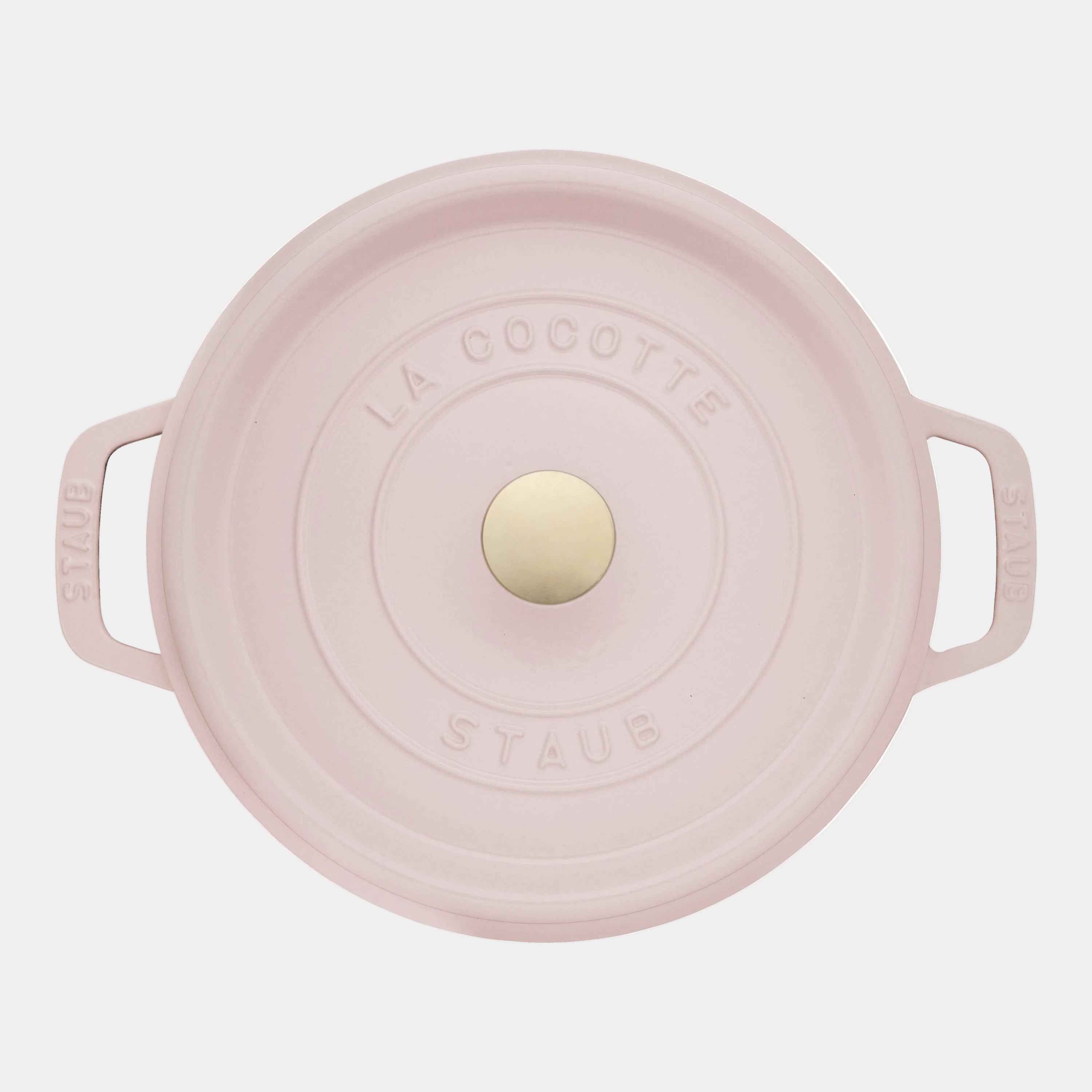 Pink Staub cocotte with a gold knob on a white background
