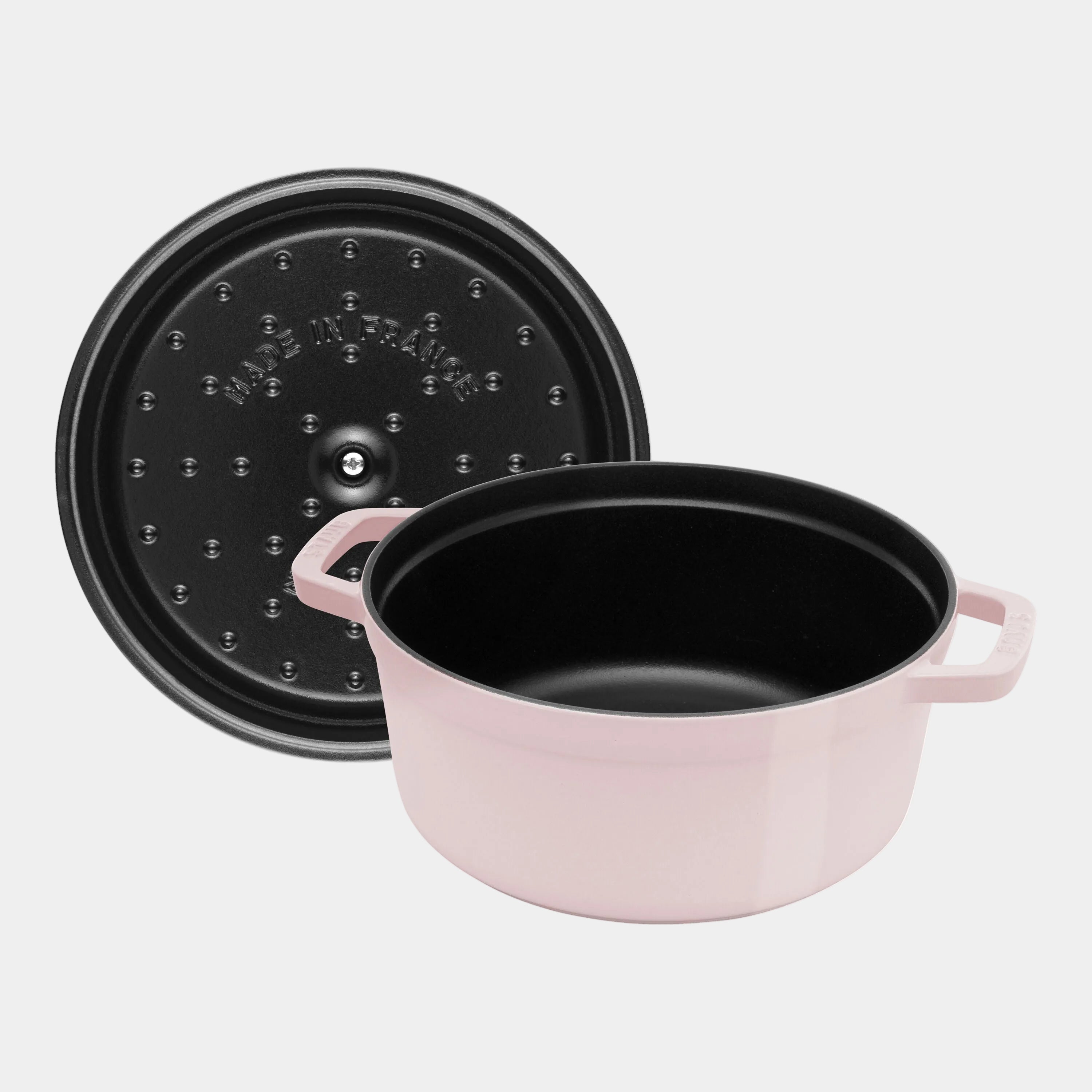 Black pot with pink handles and a black lid on a white background