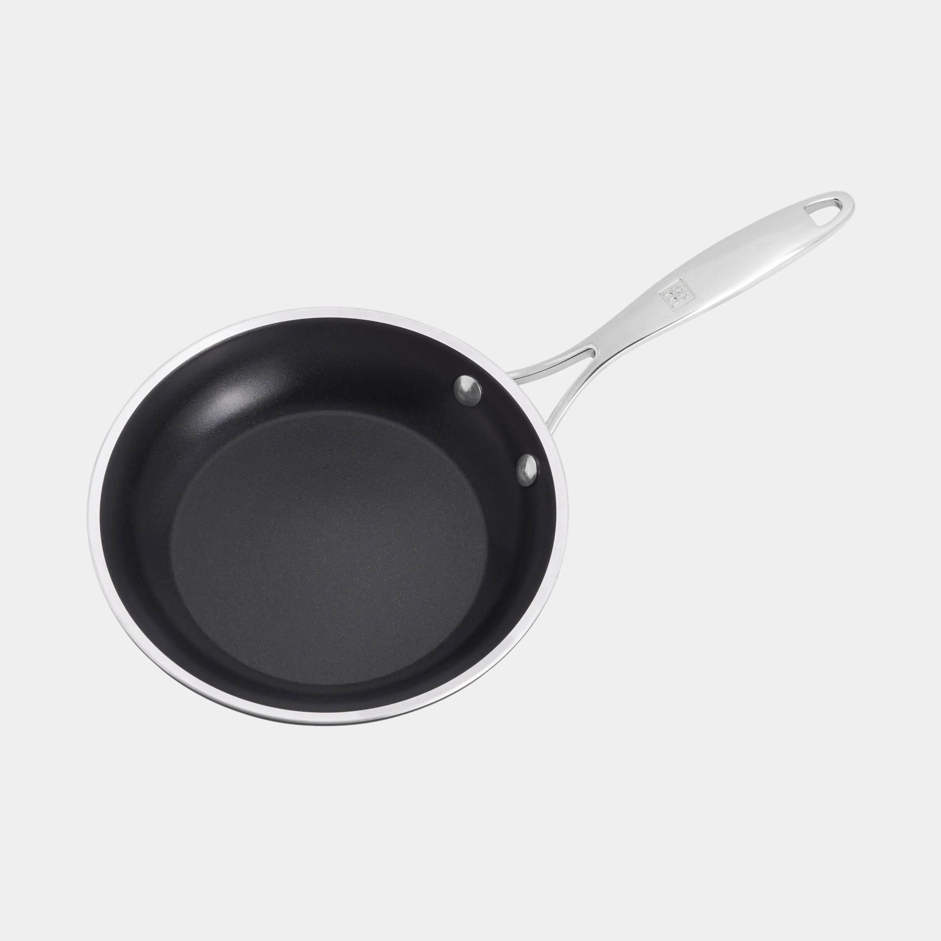 Black frying pan with a silver handle on a white background