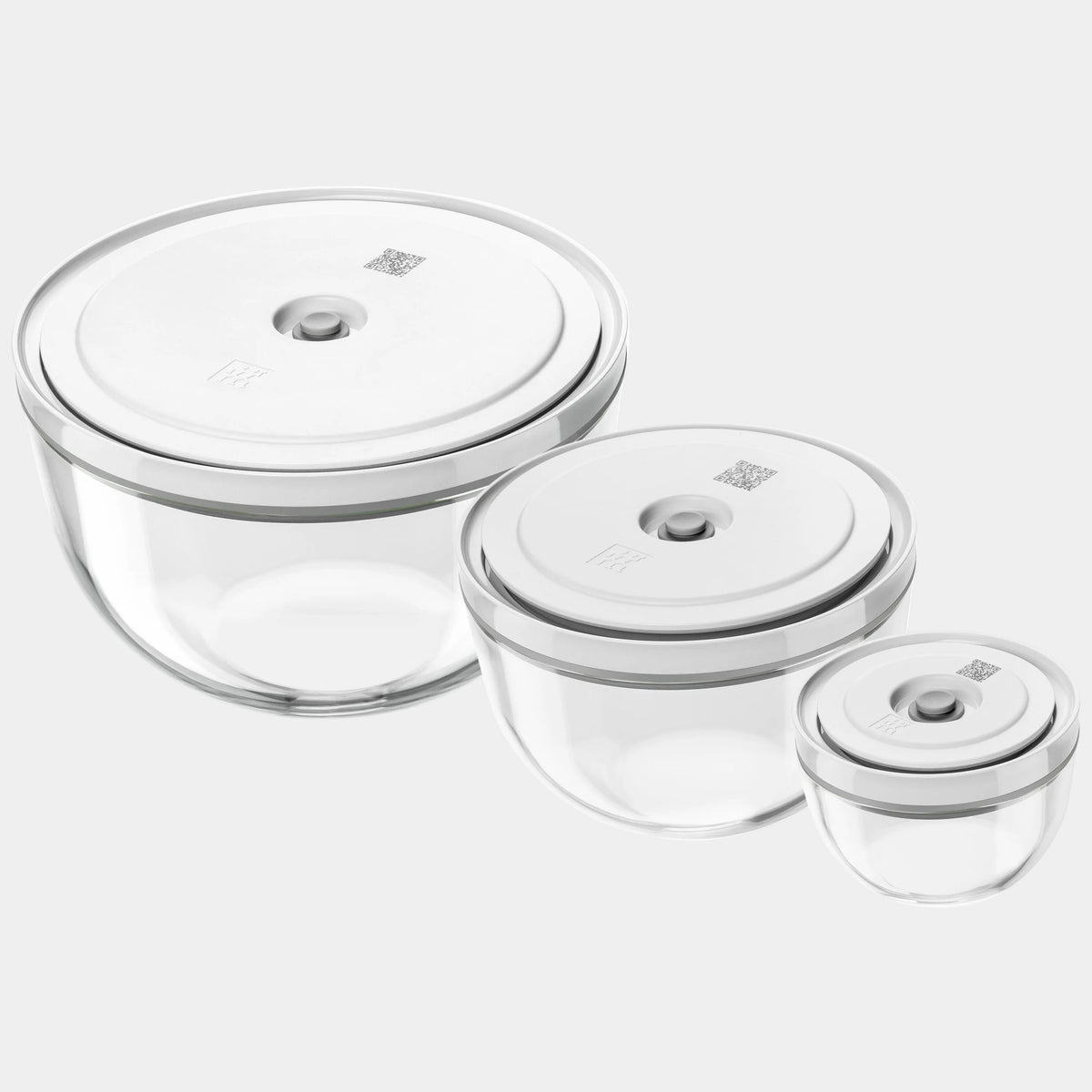 Set of three clear glass containers with silver lids on a white background