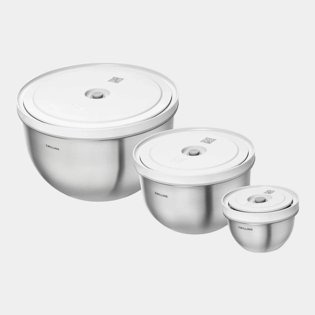 Set of three stainless steel containers with lids on a white background