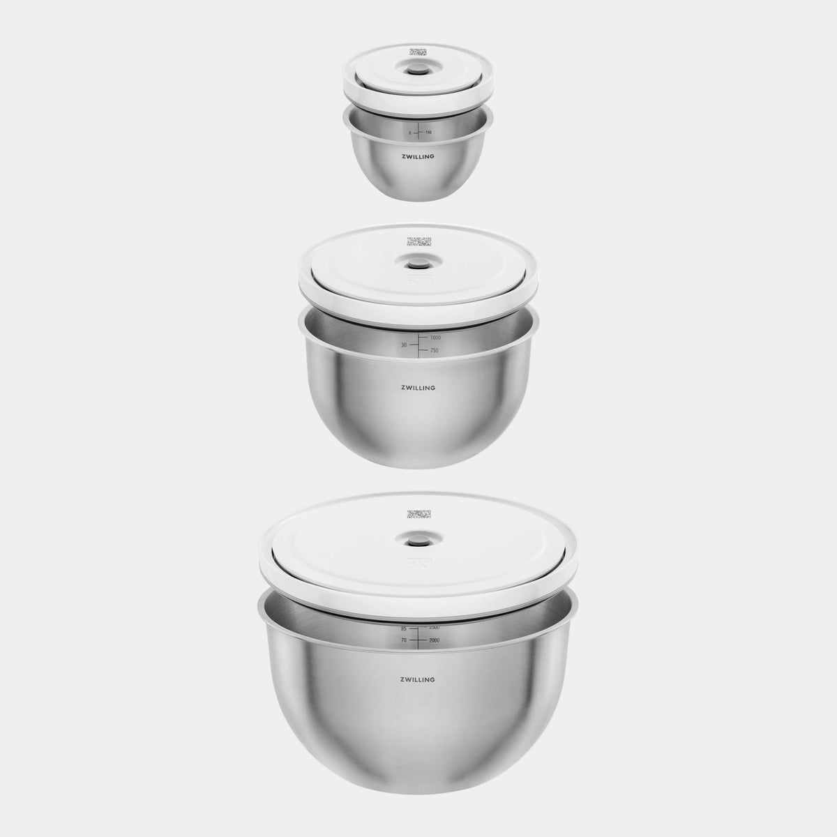 Set of stainless steel mixing bowls with lids on a white background