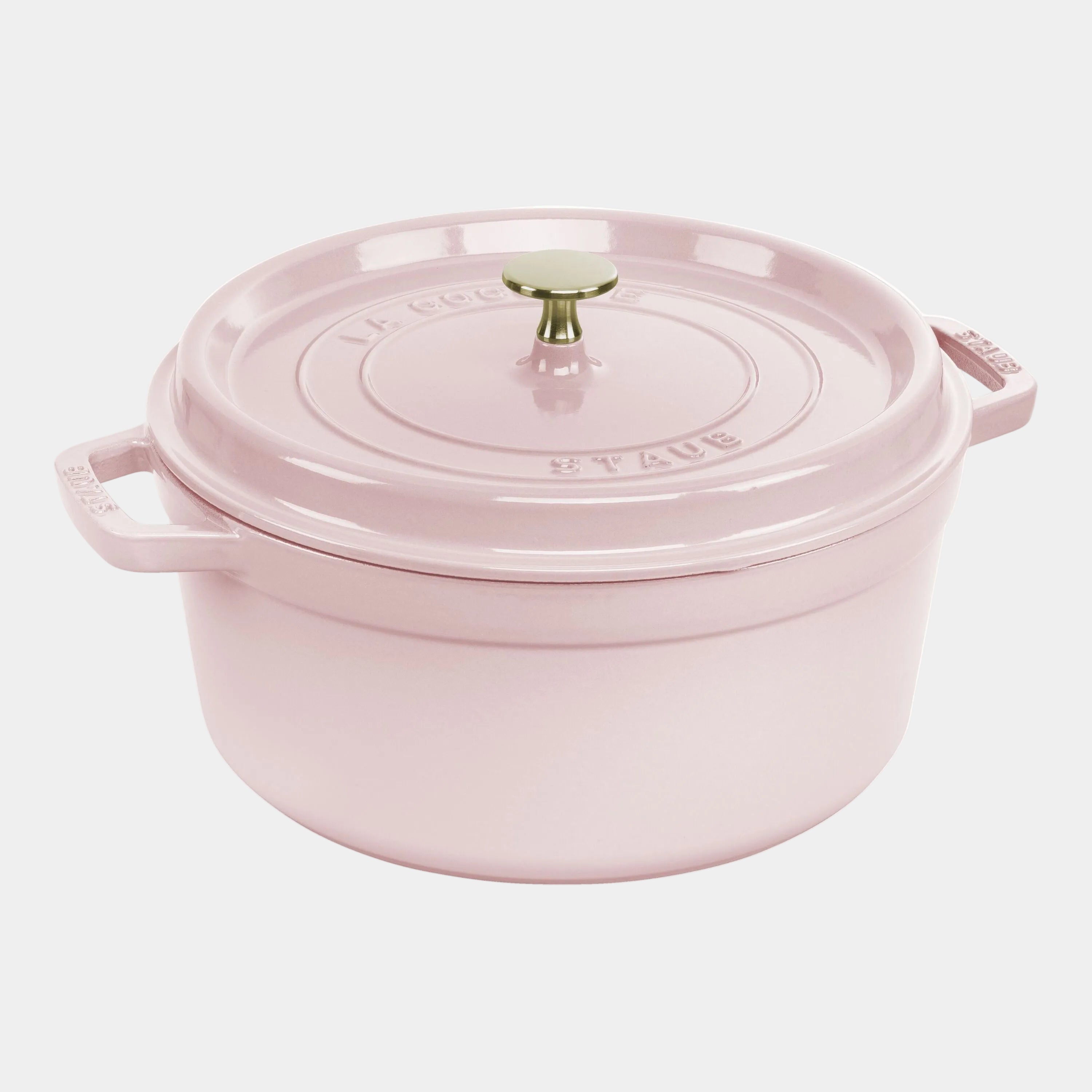 Pink Staub cocotte with a gold knob on a white background