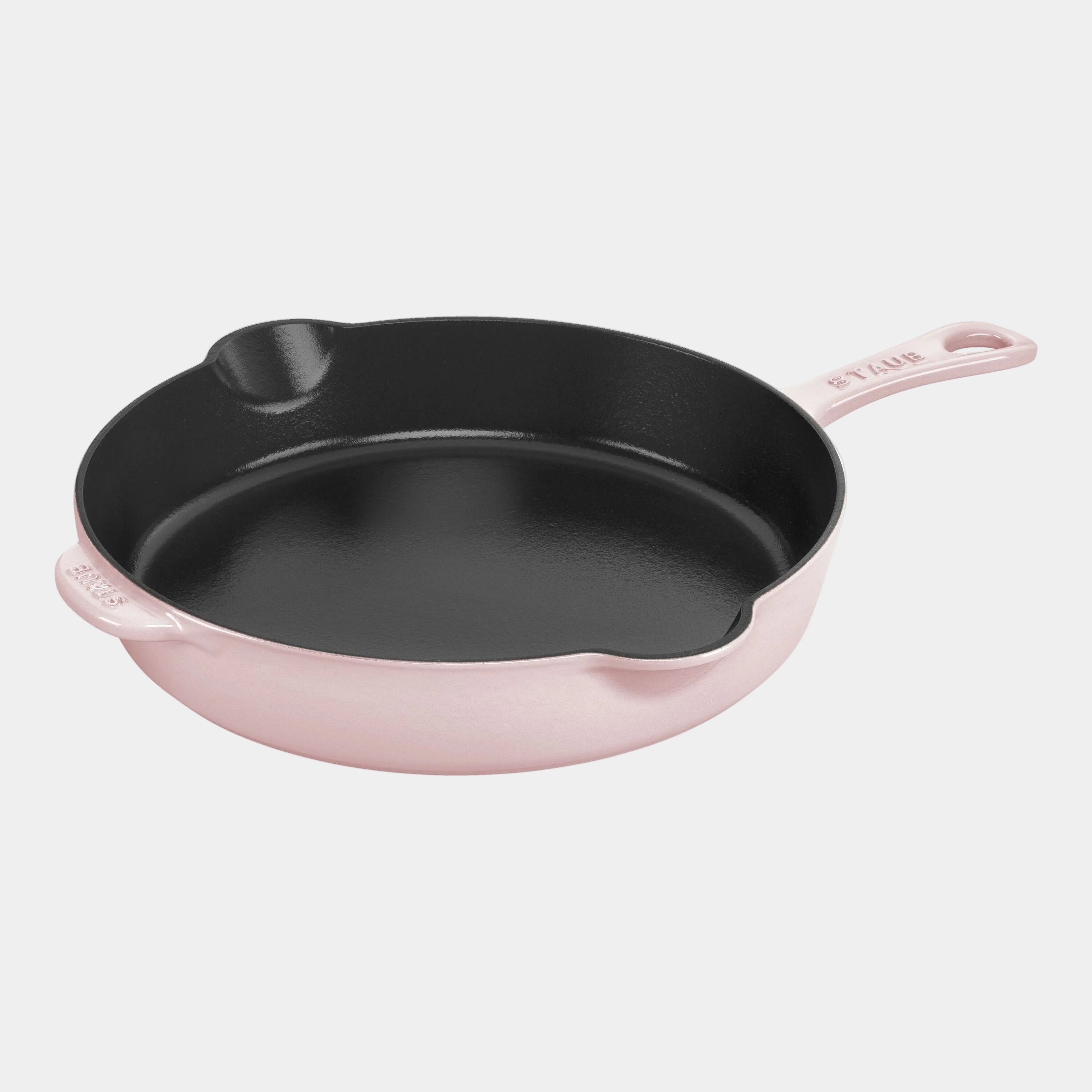 Black cast iron skillet with pink handle on a white background