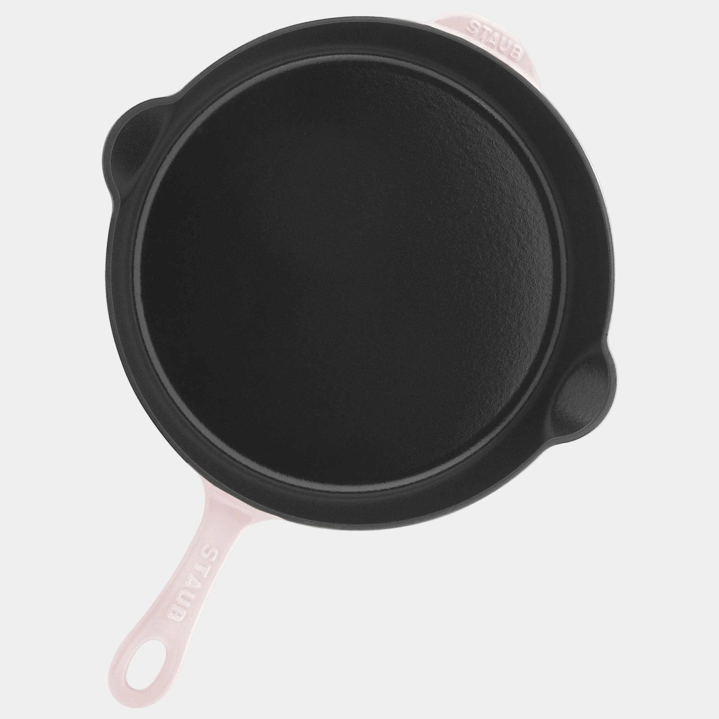 Black cast iron skillet with a pink handle on a white background