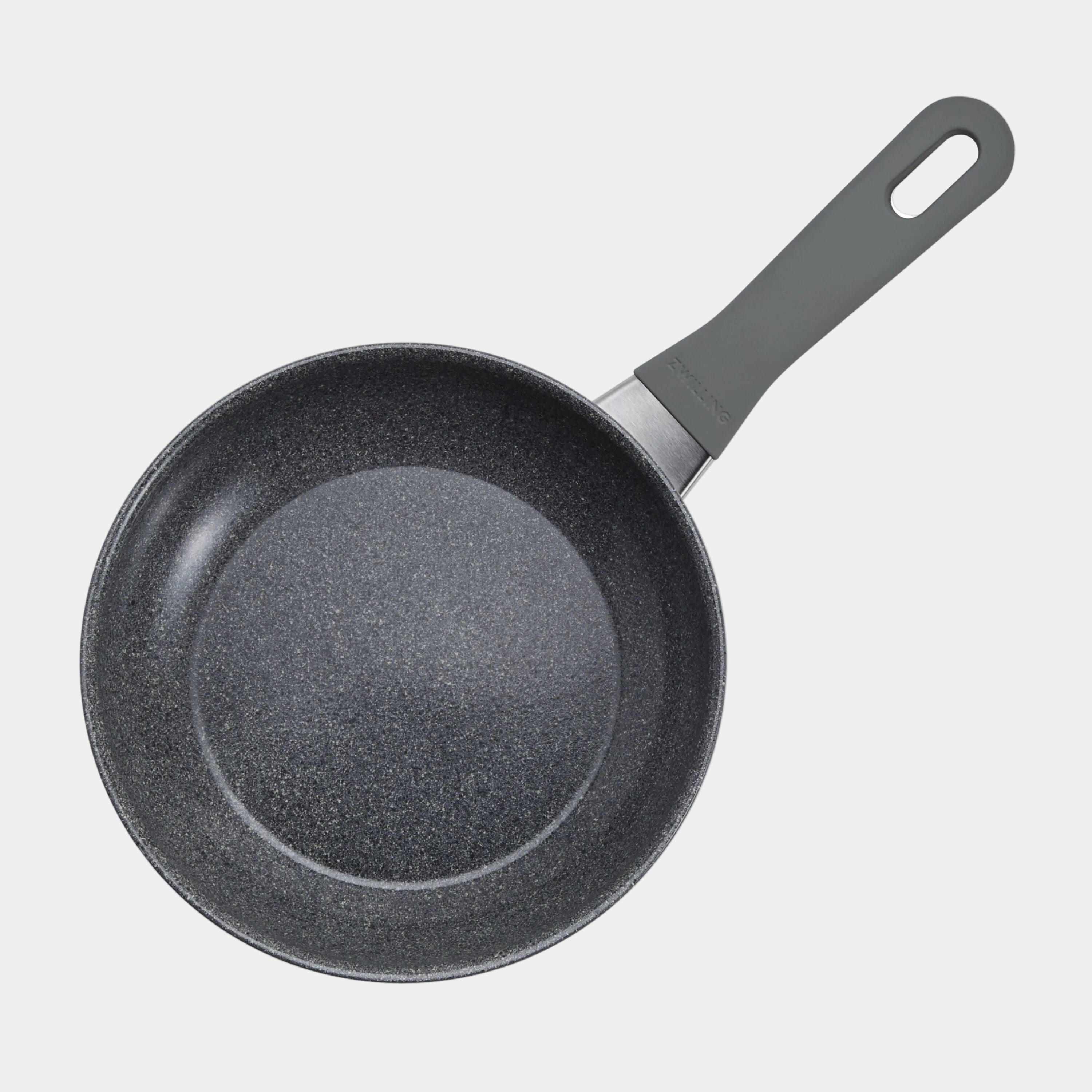 Black frying pan with a textured surface on a white background