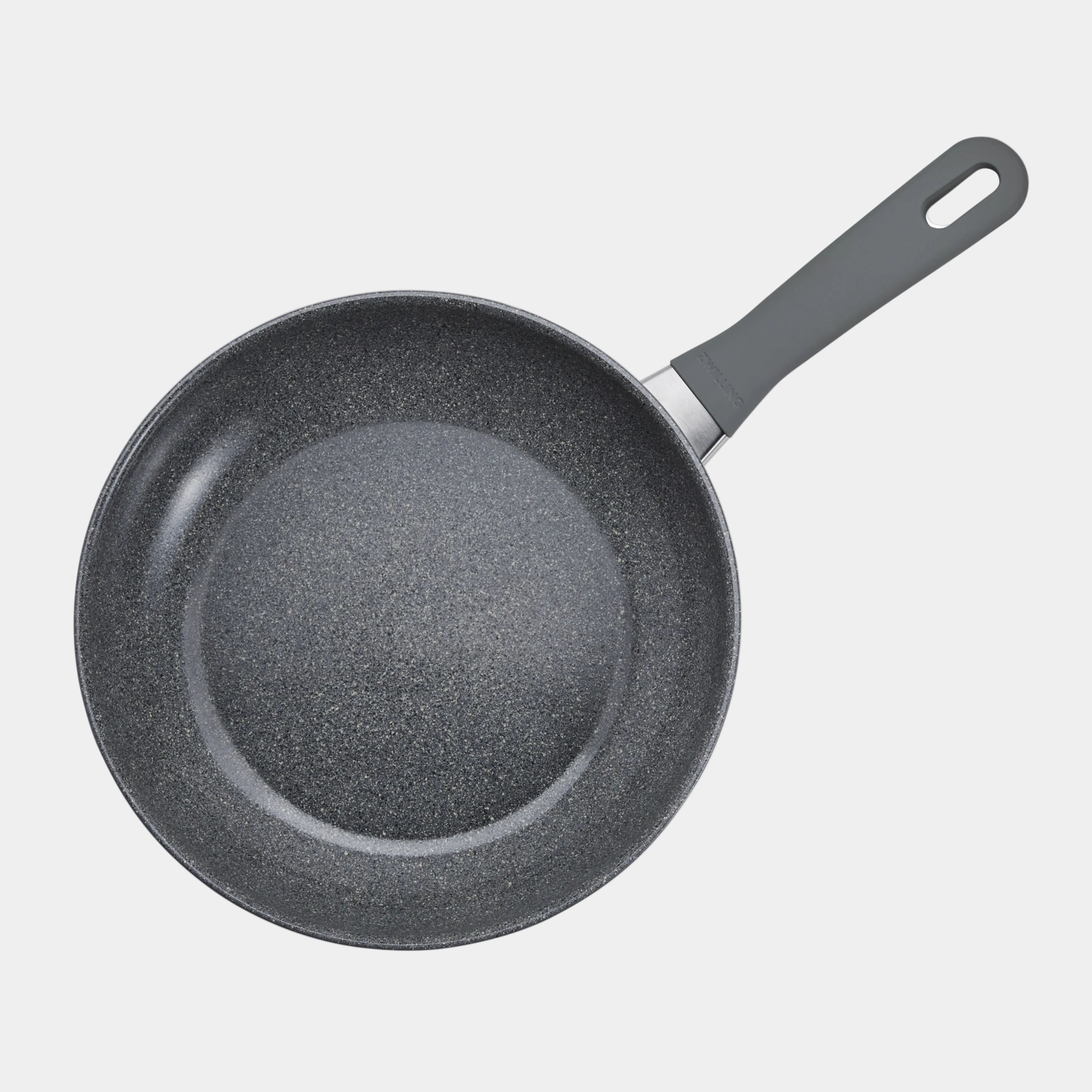 Black frying pan with speckled non-stick surface on a white background