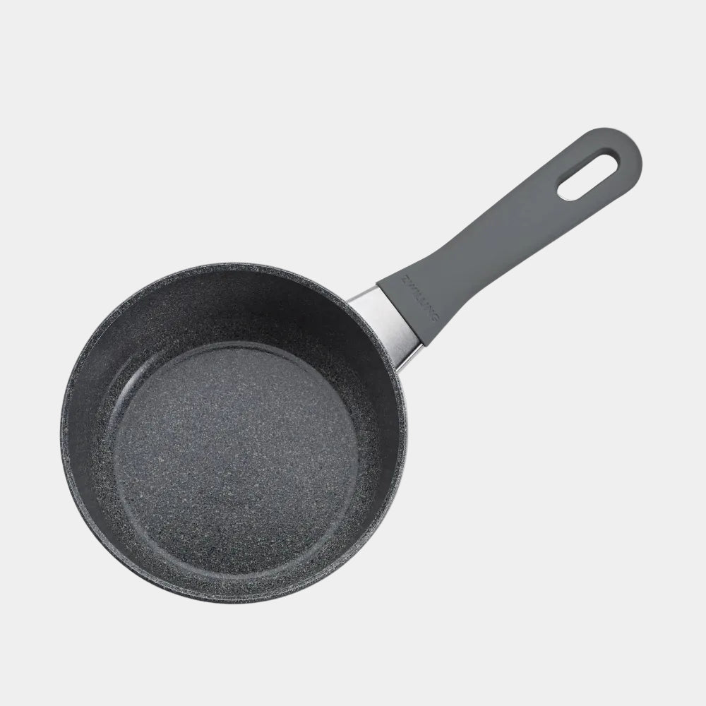 Black frying pan with a textured surface on a white background
