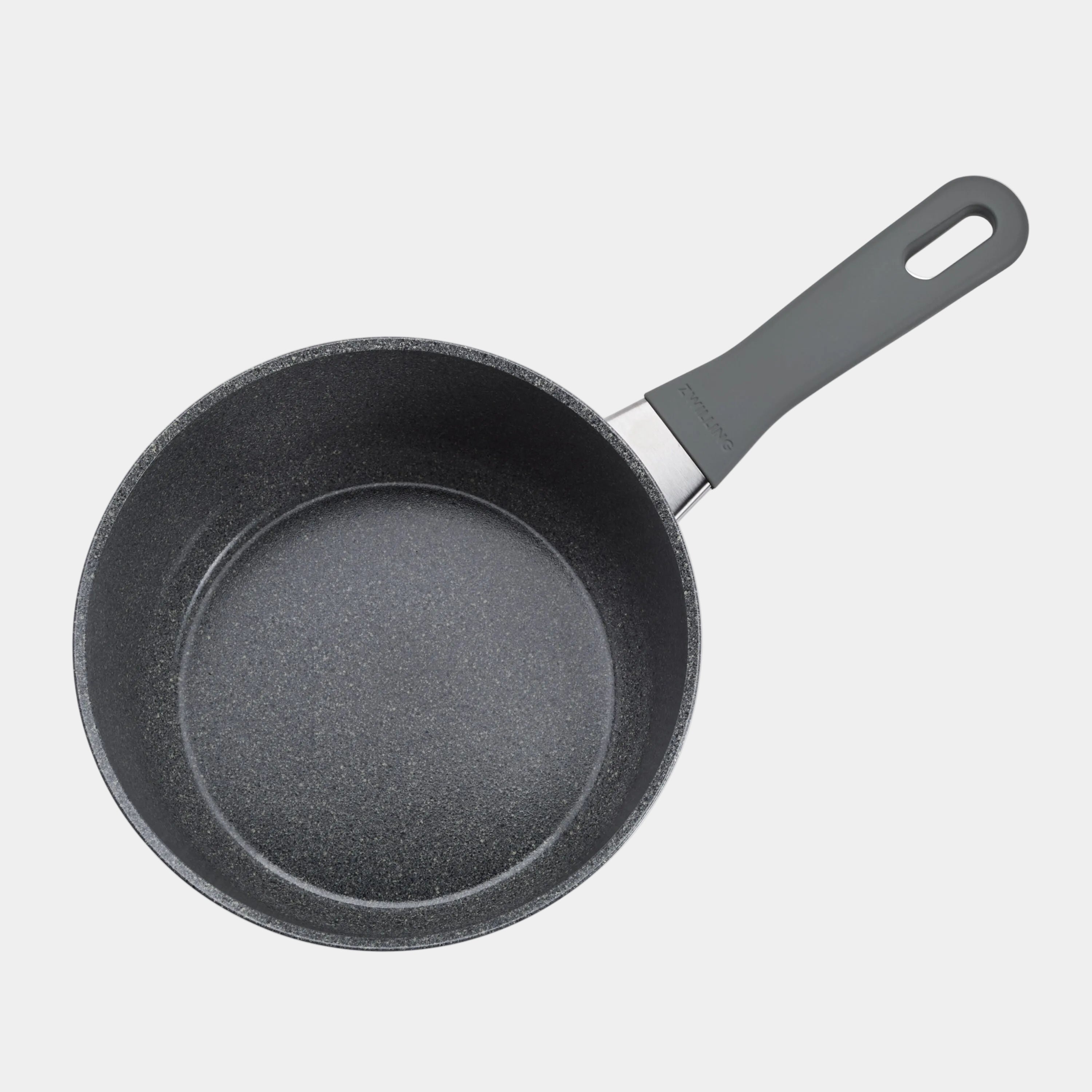 Black frying pan with a textured surface on a white background