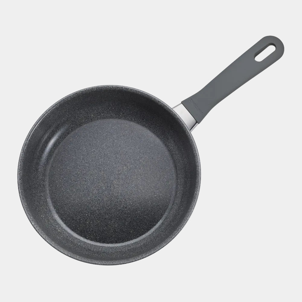 Black frying pan with a textured surface on a white background