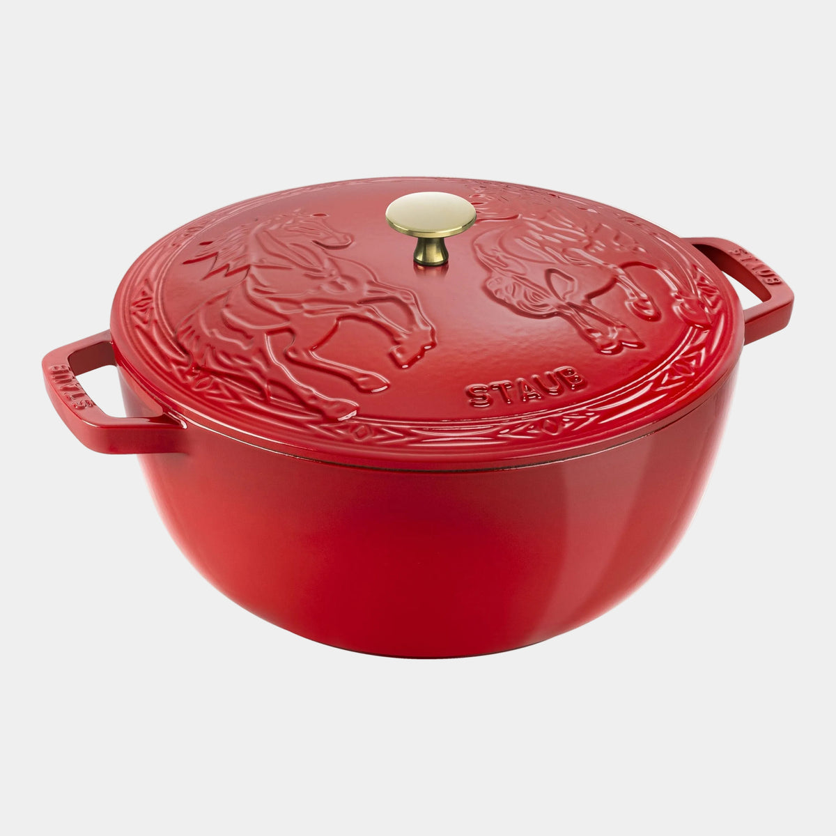 Red Staub cocotte with horse design on a white background