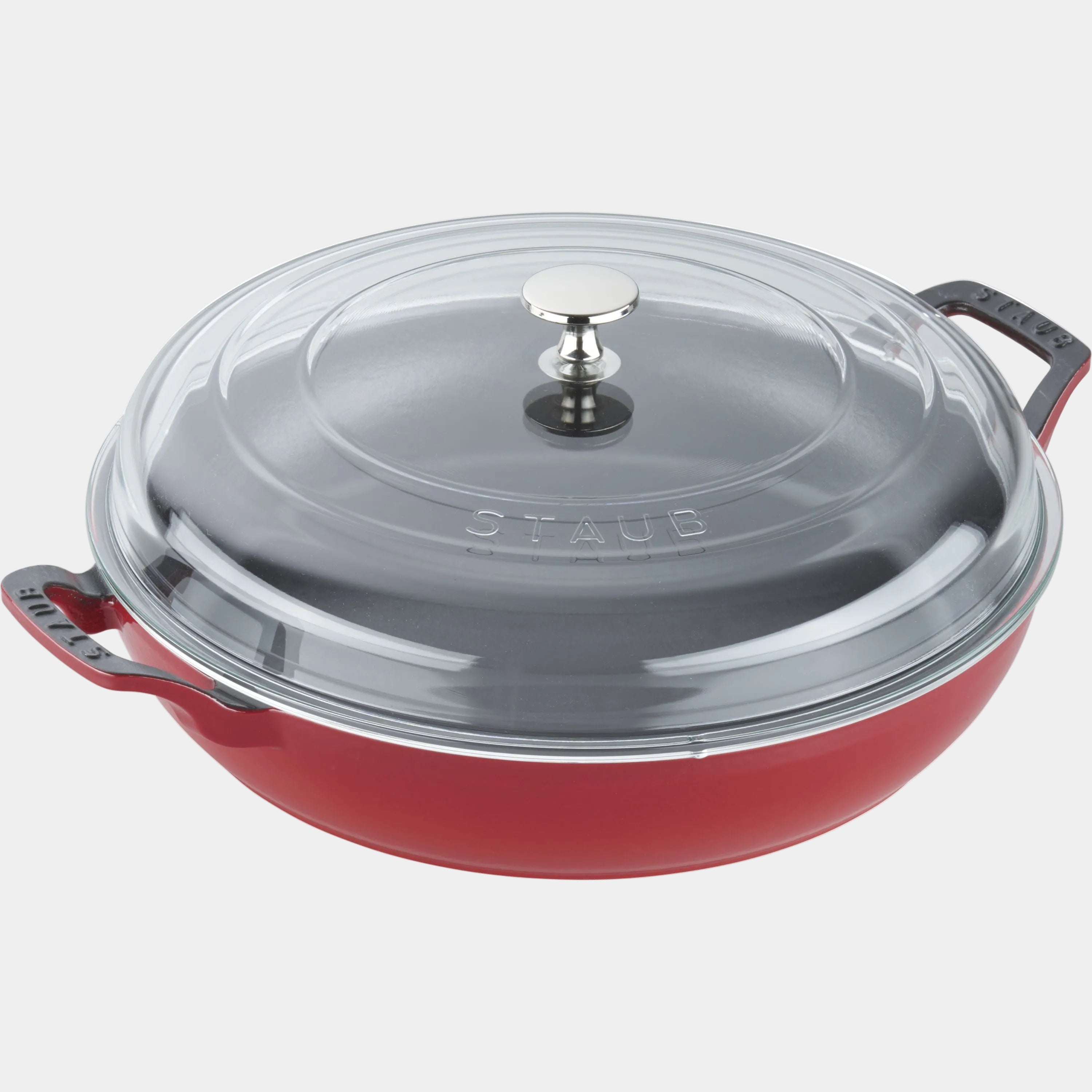 Red Staub cookware with a clear glass lid on a white background