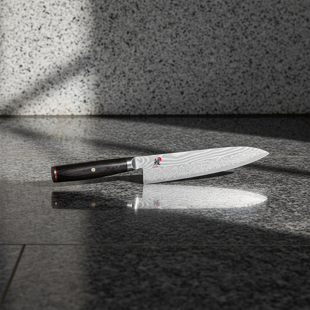Chef's knife with a black handle on a white background