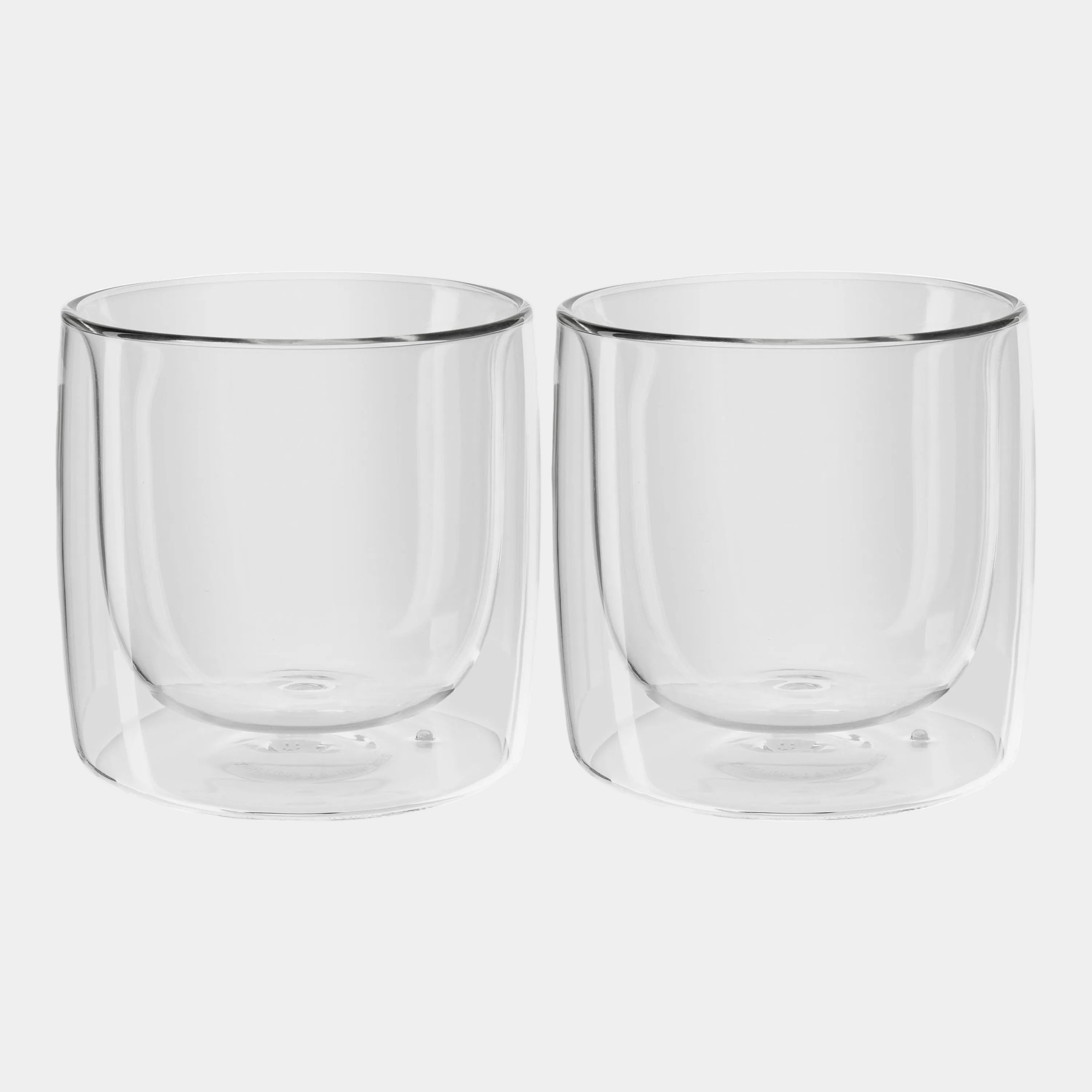 Two clear glass tumblers on a white background