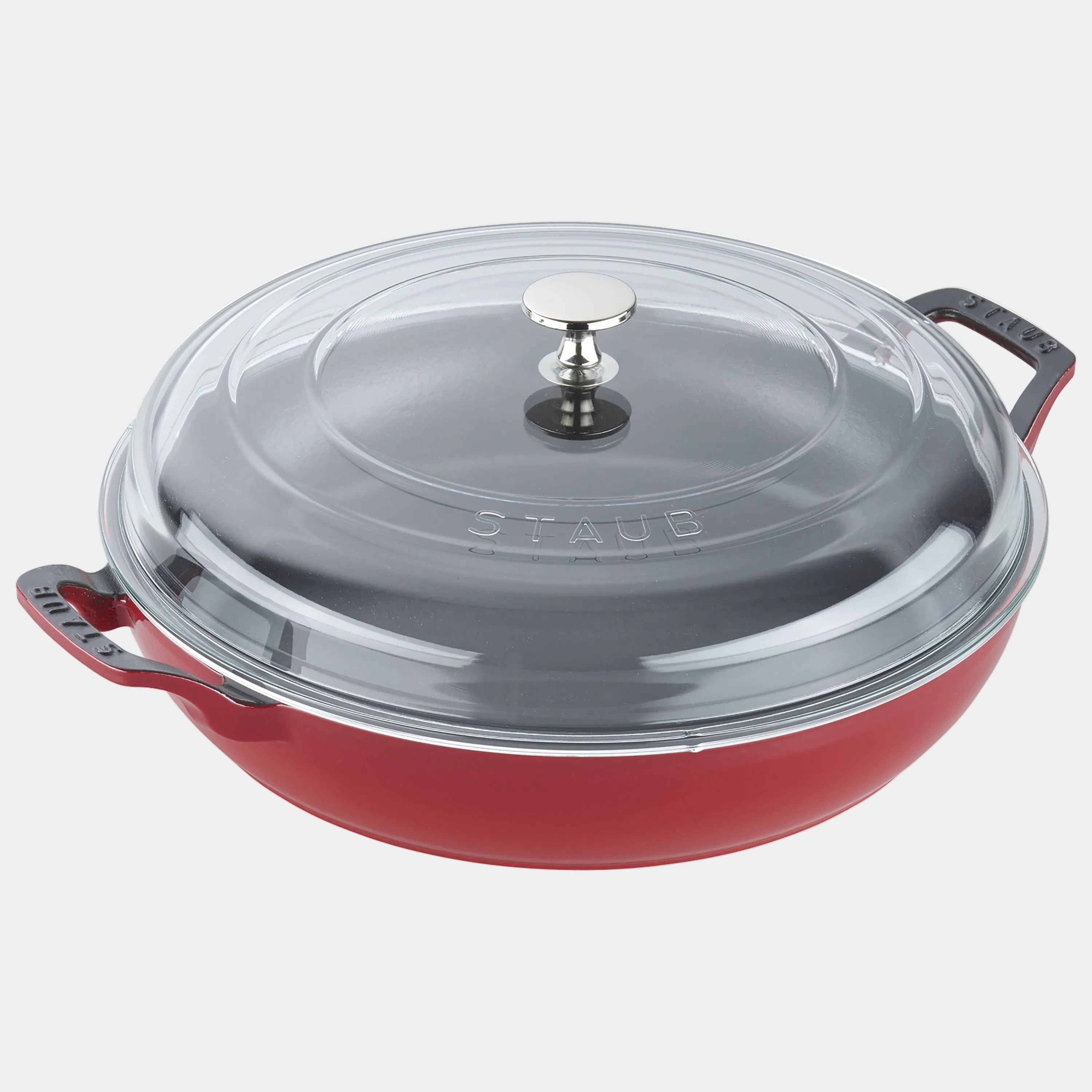 Red Staub cookware with a clear glass lid on a white background