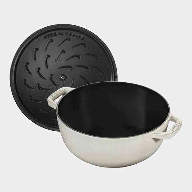 White cast iron pot with black lid on a white background