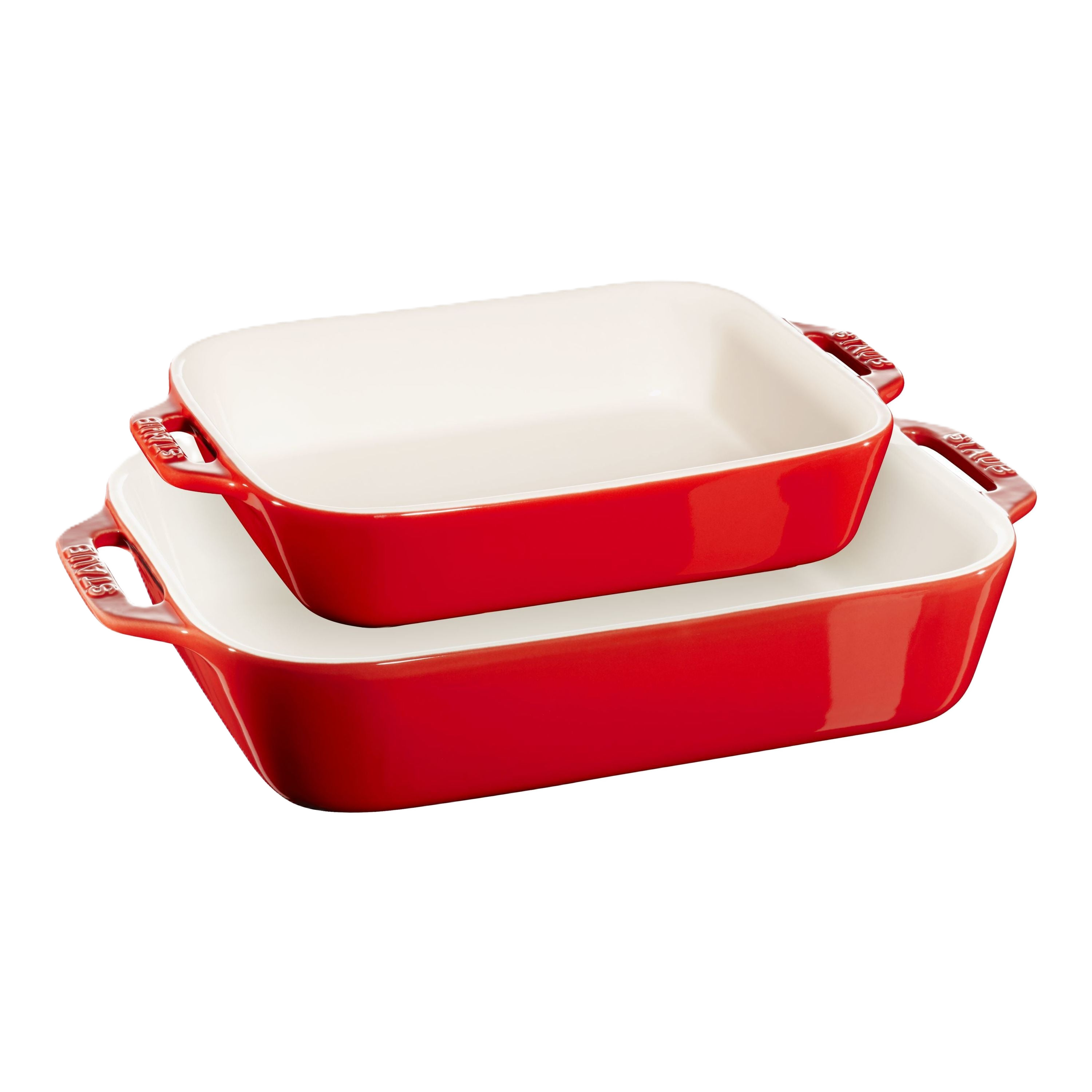 Set of two red ceramic baking dishes with white interiors on a white background