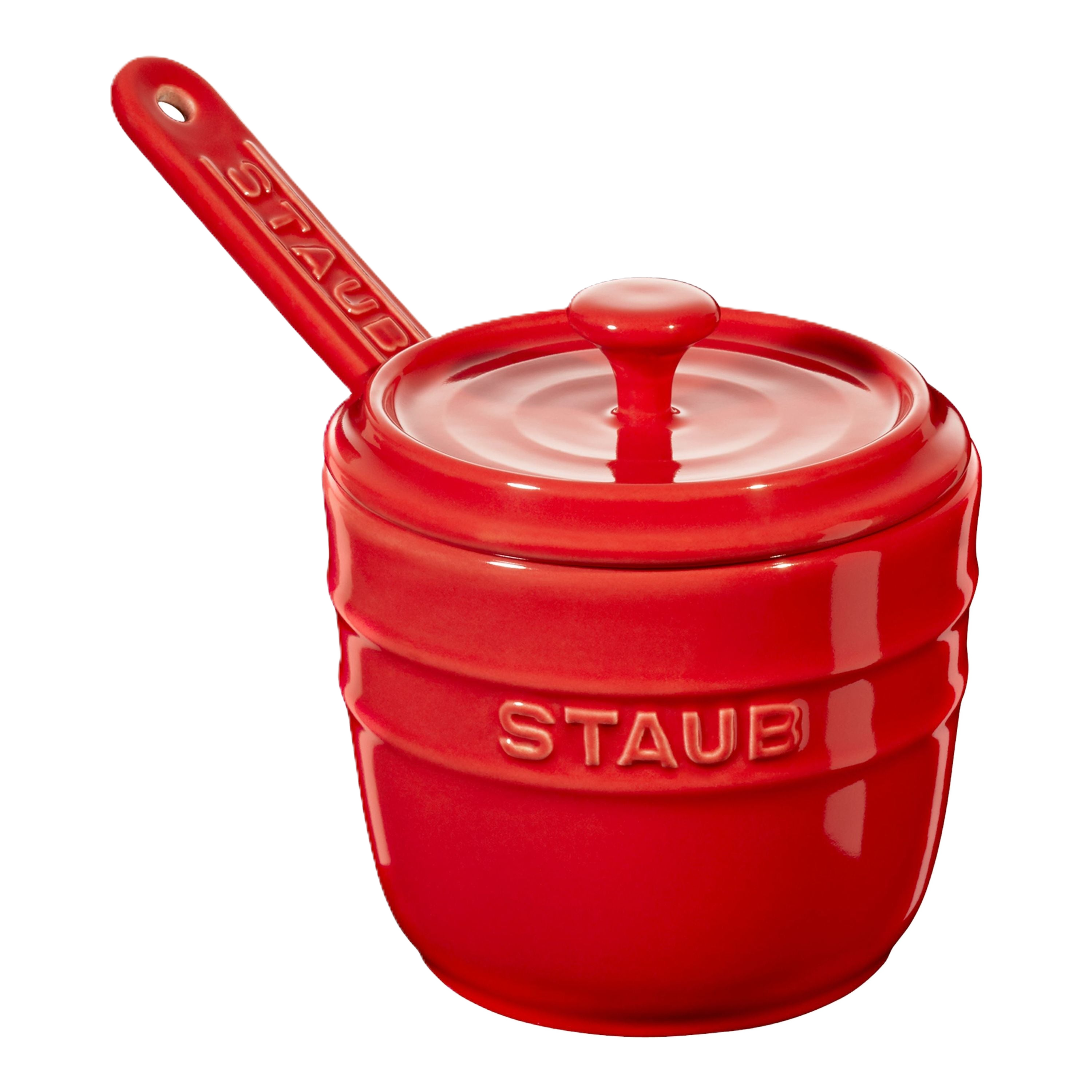 Red Staub ceramic pot with lid and handle on a white background