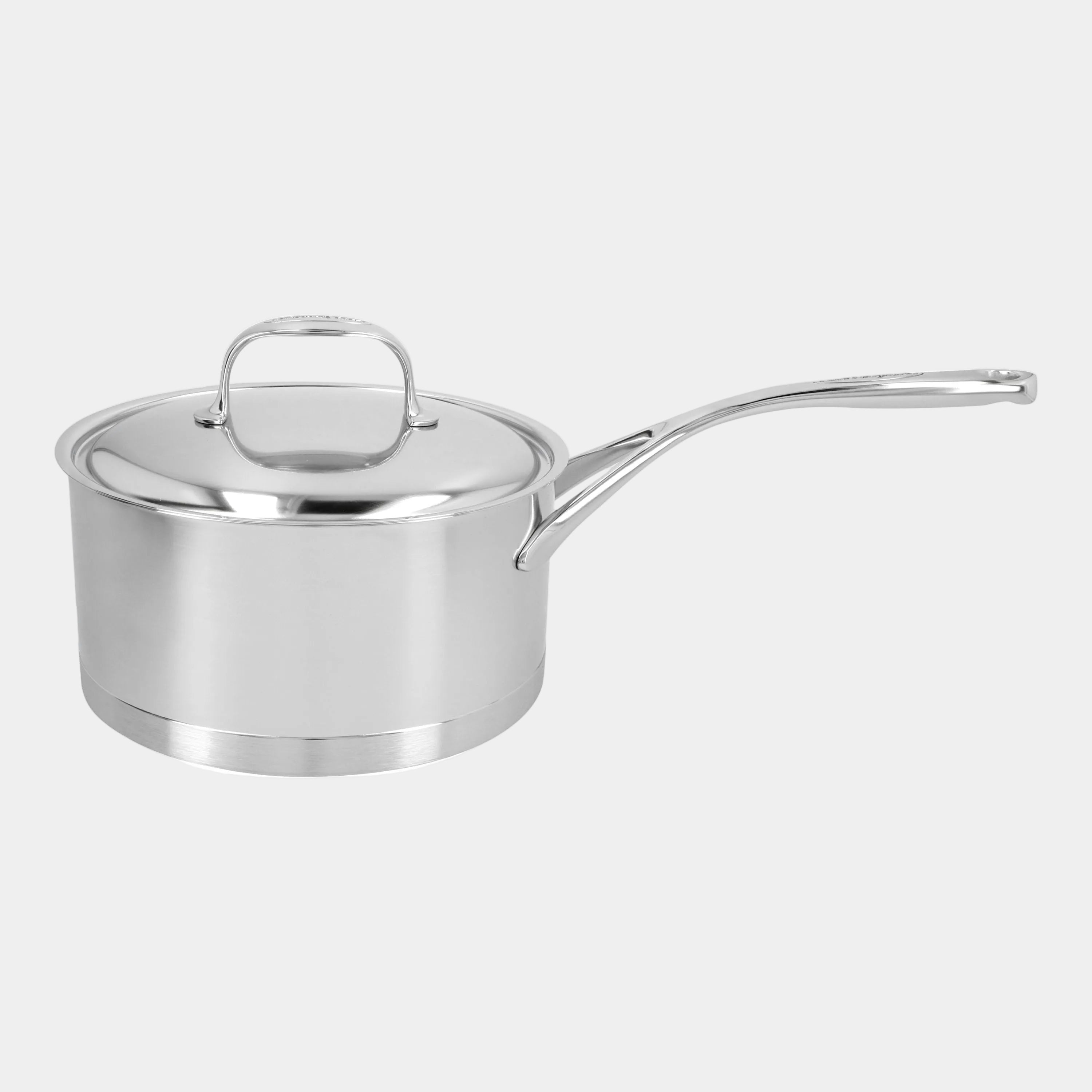 Stainless steel saucepan with lid on a white background