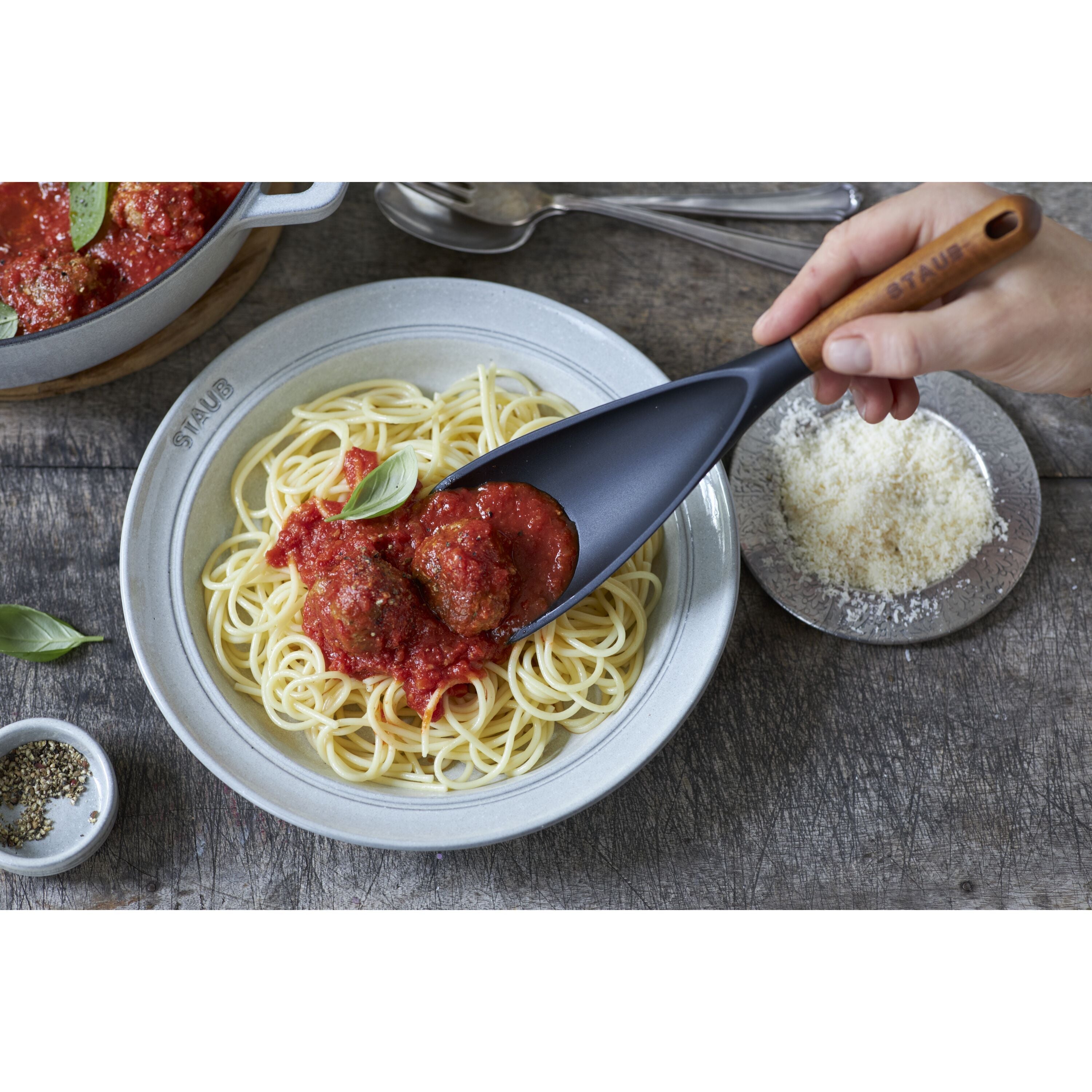 STAUB Silicone Multi Spoon serving spaghetti with meatballs in a bowl, showcasing ergonomic design and black silicone material.