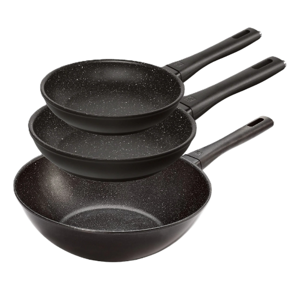 Set of three black frying pans with speckled interior on a white background