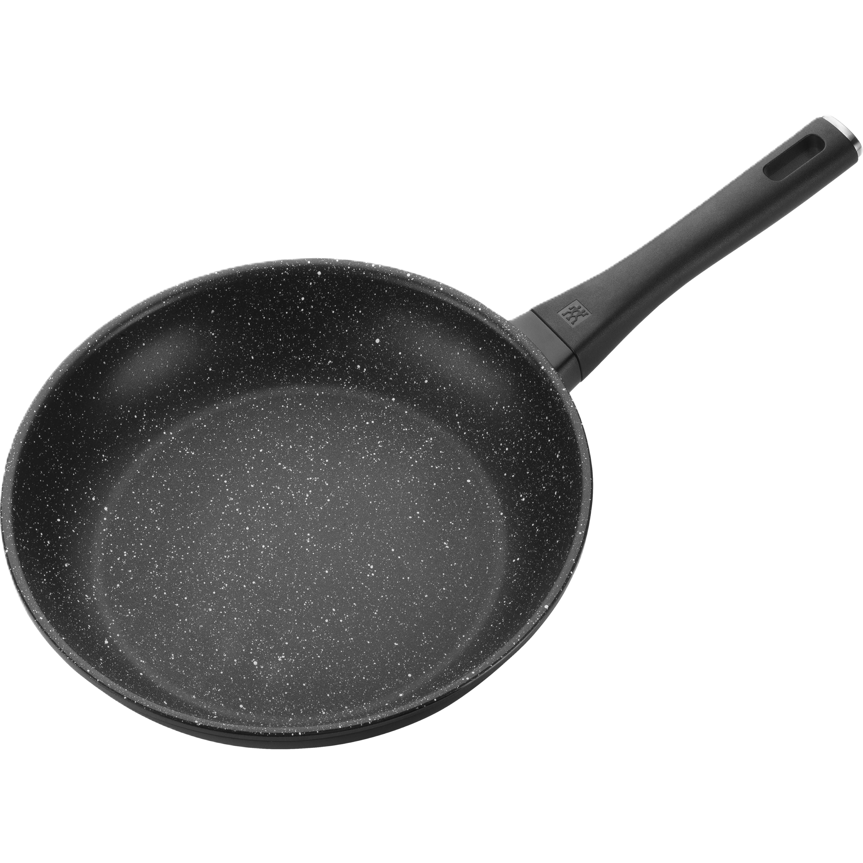 Black frying pan with speckled surface on a white background