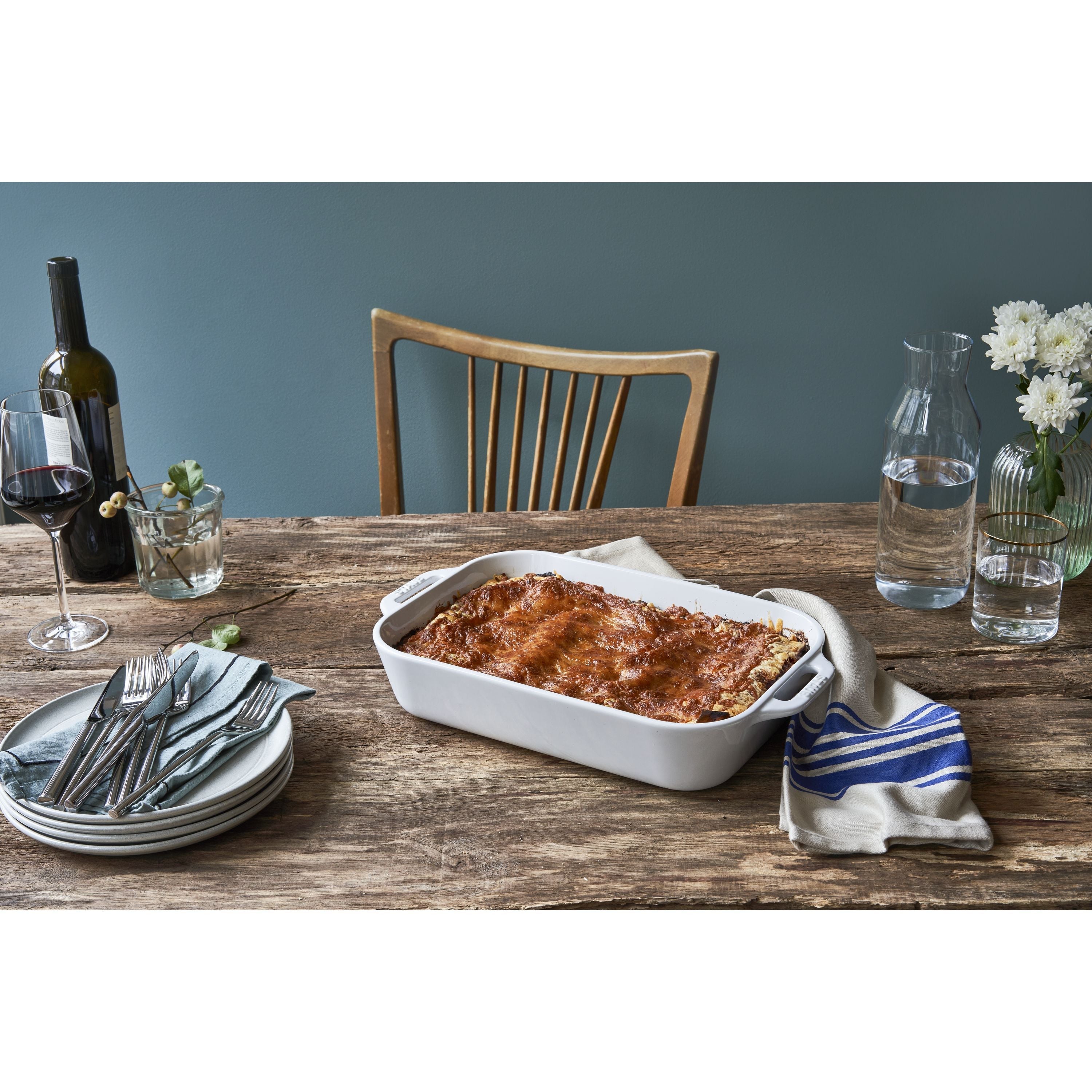 STAUB Ceramique 4.4 L Ceramic Rectangular Oven Dish, White with baked lasagna on a rustic dining table setting
