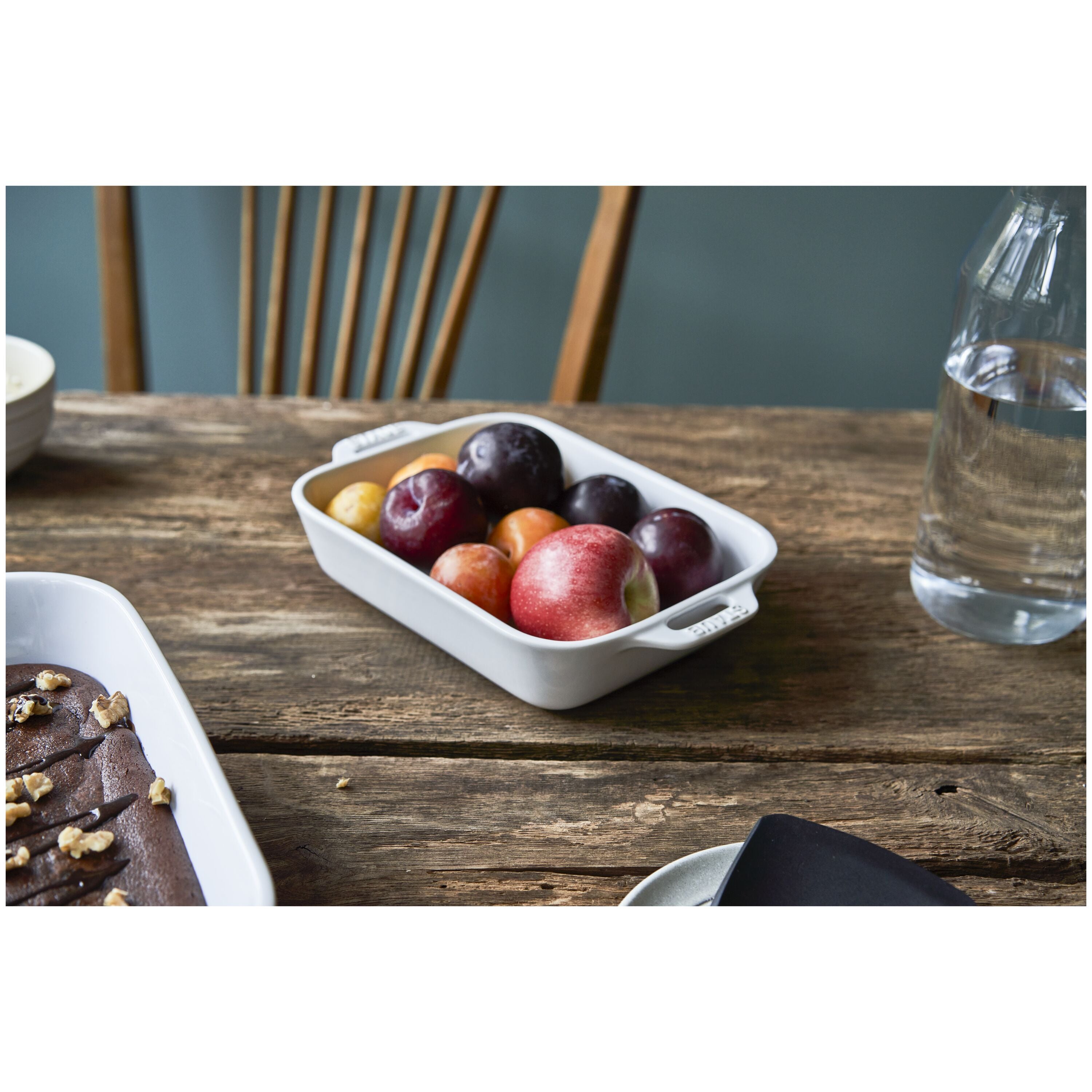 STAUB Ceramique Ceramic Rectangular Oven Dish holding a variety of fresh fruits on a rustic wooden table.