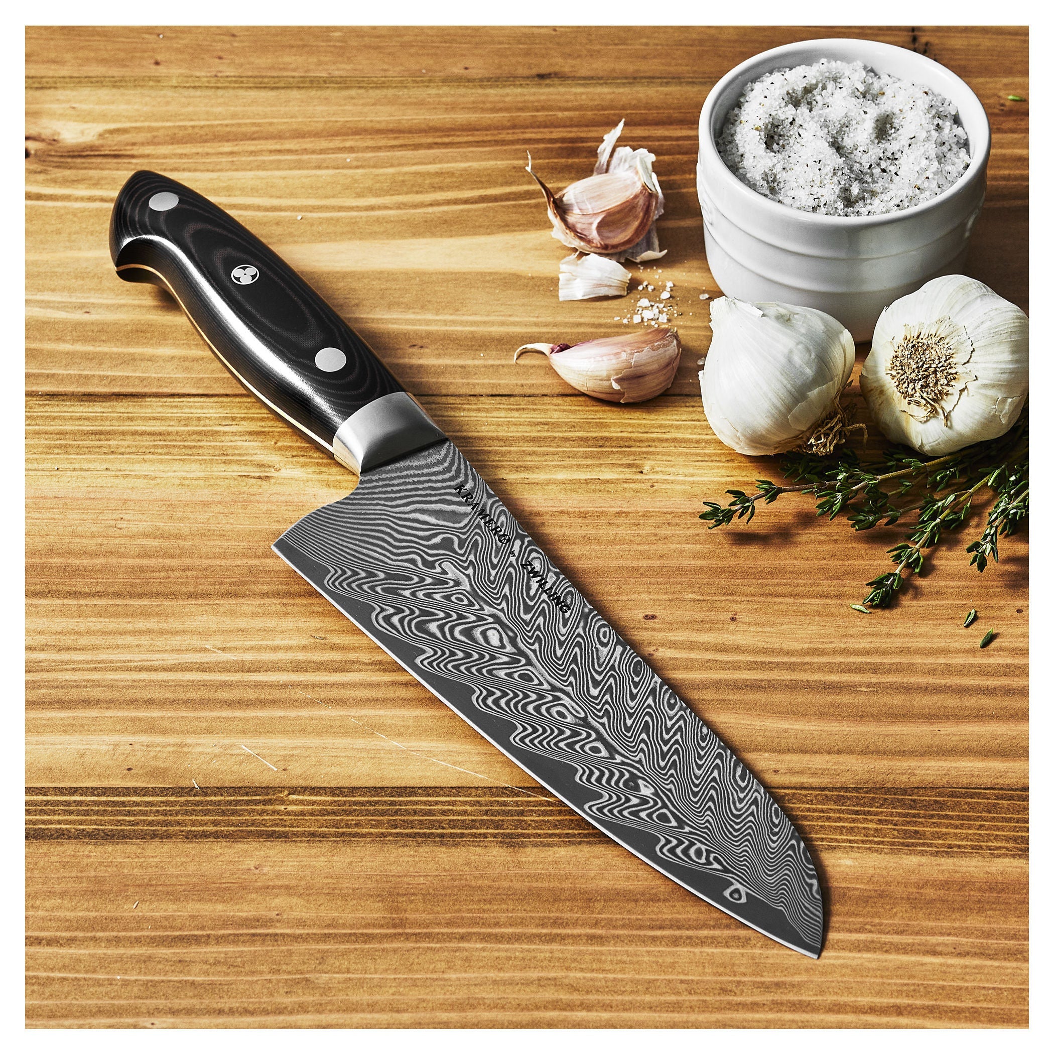 Decorative chef's knife on a wooden surface with garlic and salt.