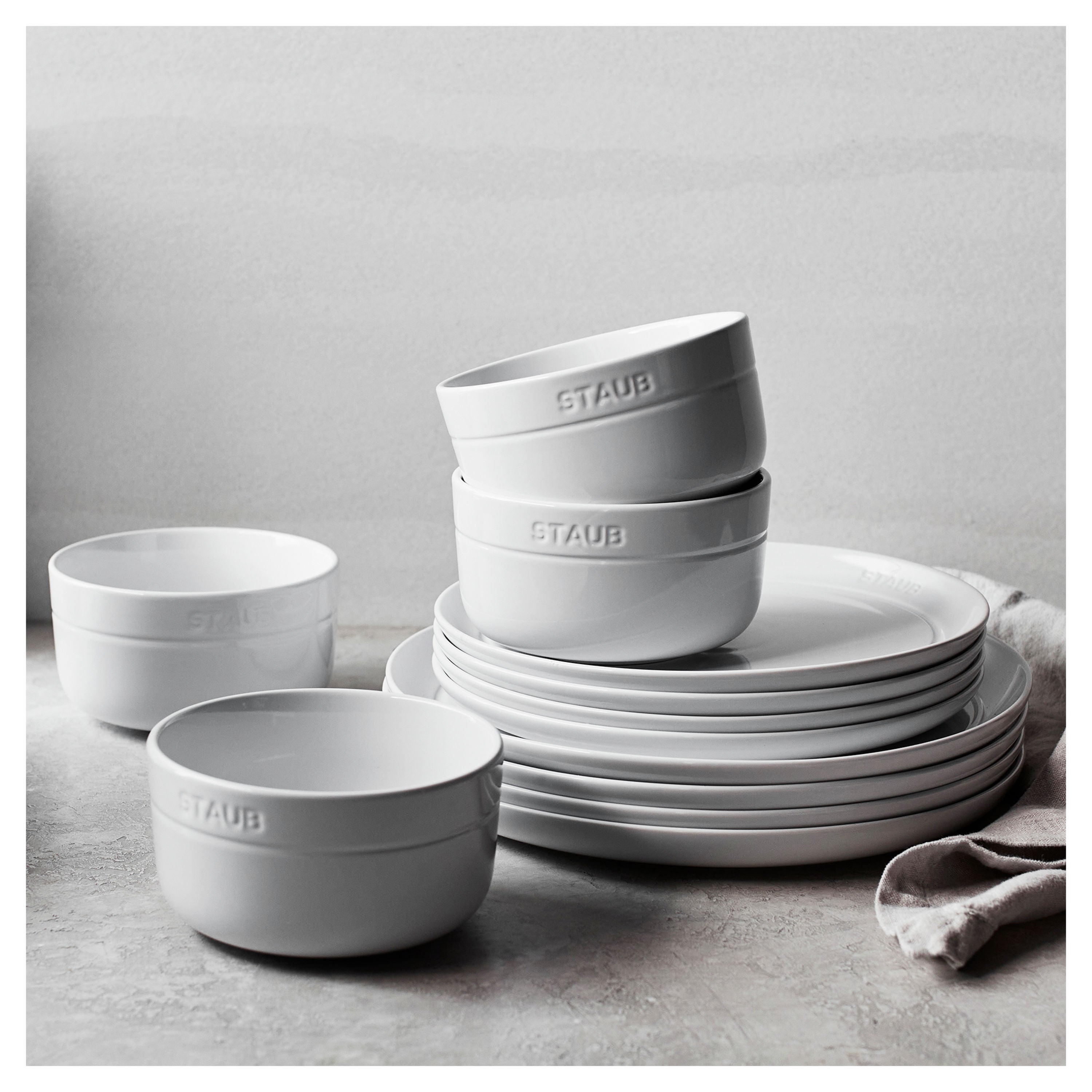 Staub ceramic dinnerware set on a neutral background