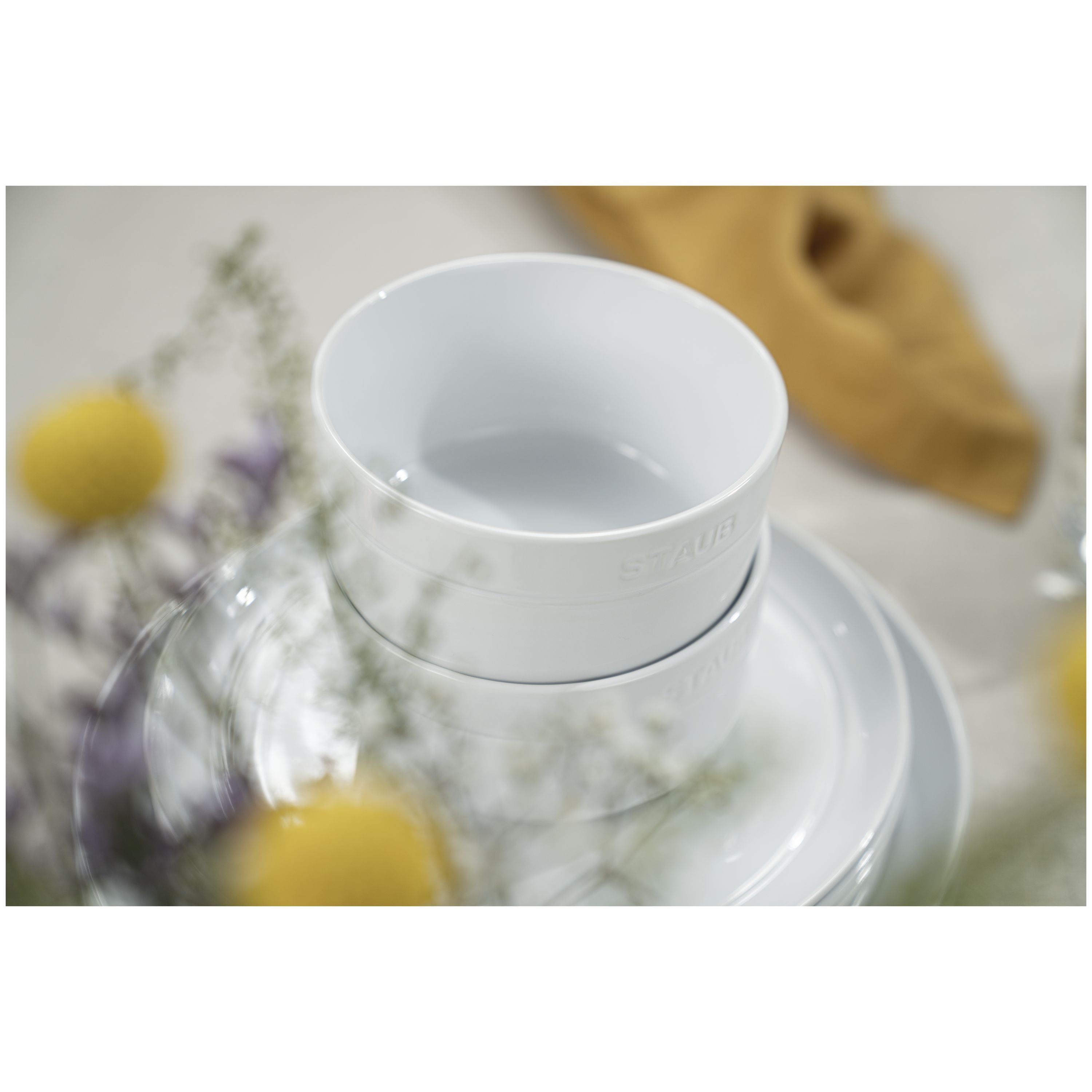 STAUB Dining Line 4 Piece Ceramic Bowl Set, White stacked with flowers in the background.