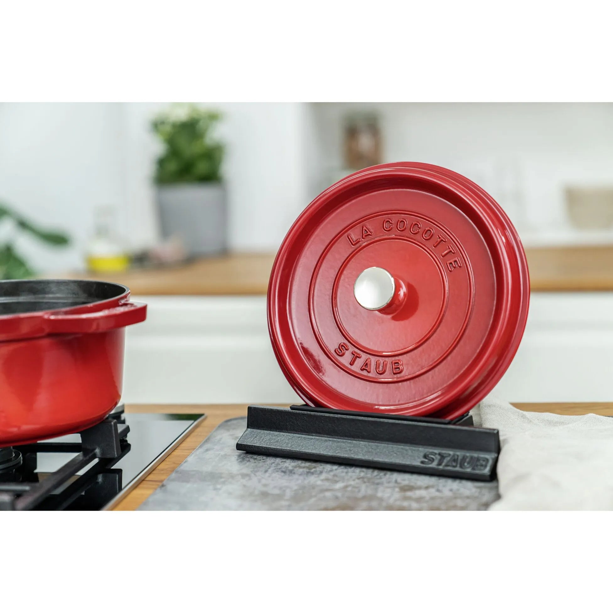 Red cocotte lid on STAUB Cast Iron Lid Holder on kitchen counter