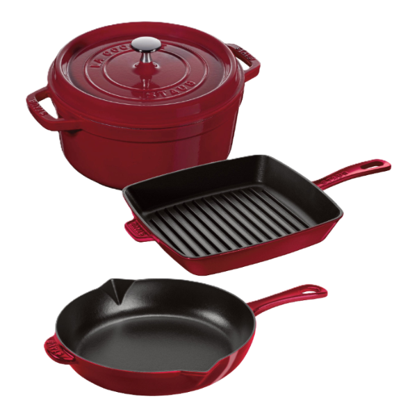 Red cookware set with a pot, two skillets, and a grill pan on a white background