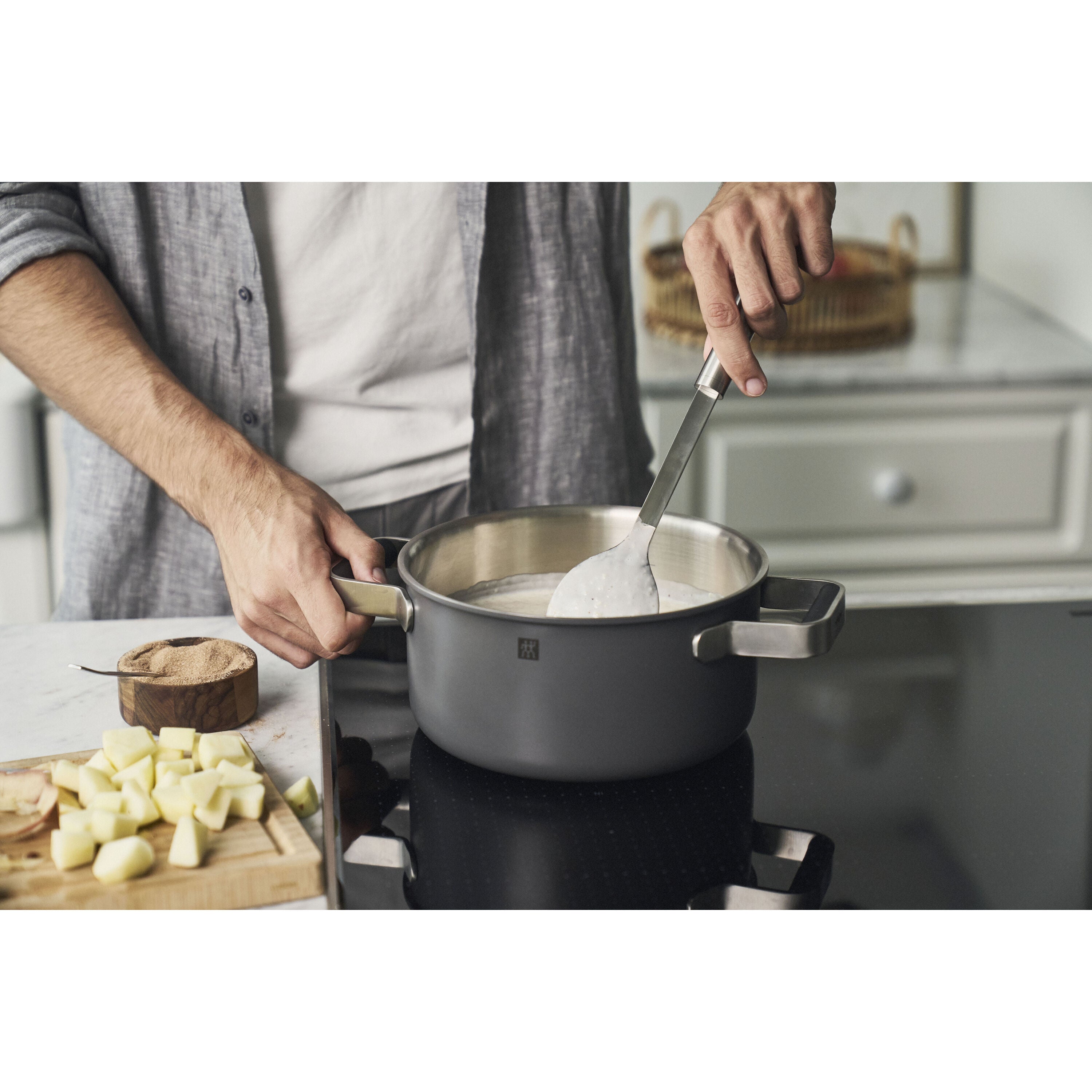 Person cooking in a kitchen with a pot on a stove