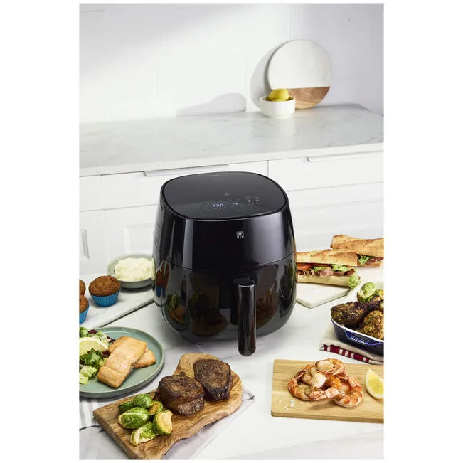 ZWILLING CERAMIC COATED Air Fryer, Black on a kitchen counter with various foods around it