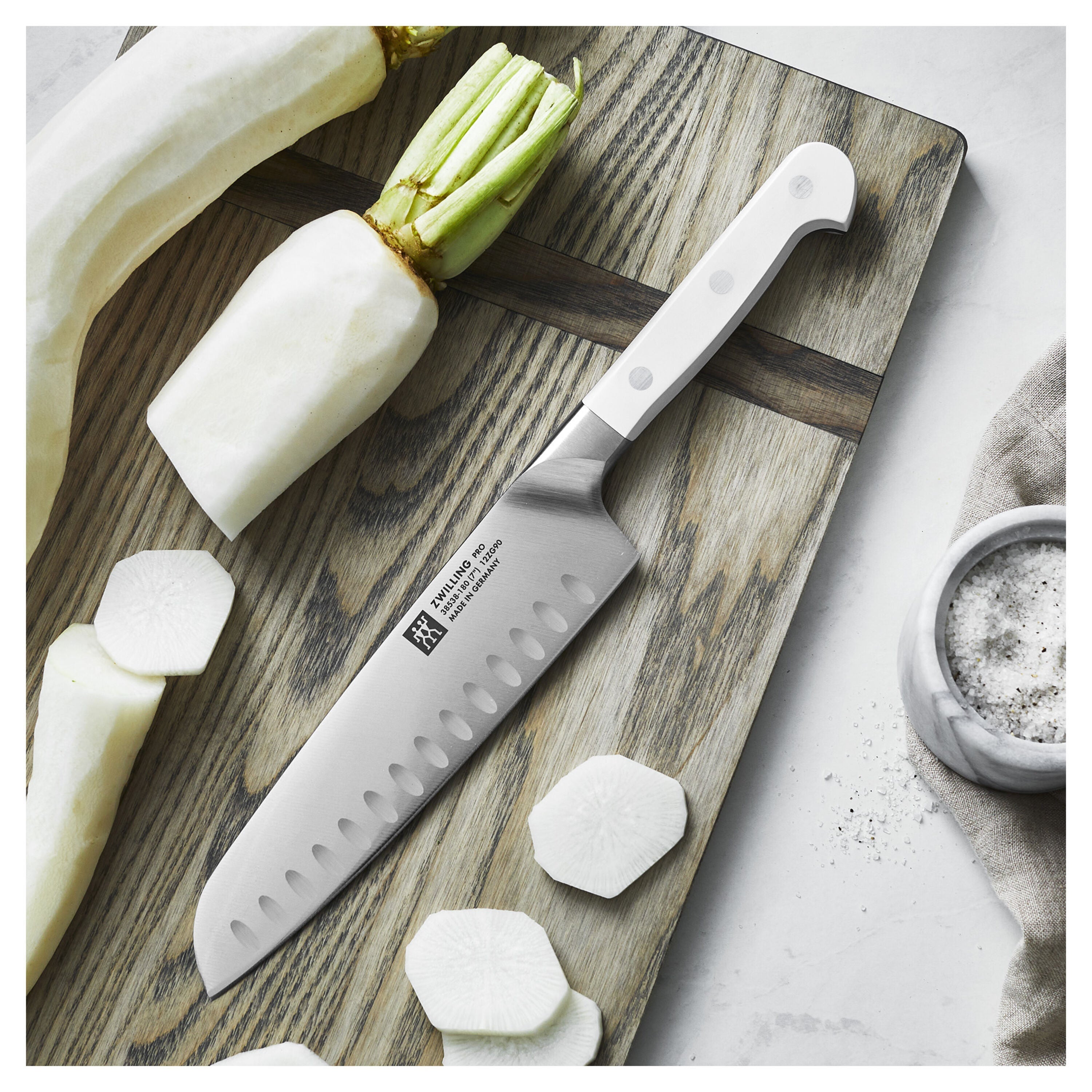 Knife on a wooden cutting board with sliced radishes