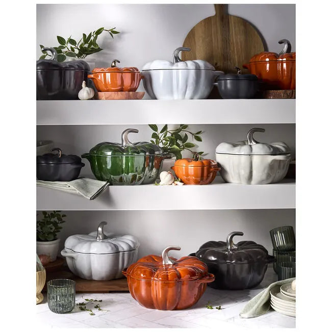 Shelves with colorful ceramic cookware and decorative items on a white surface.