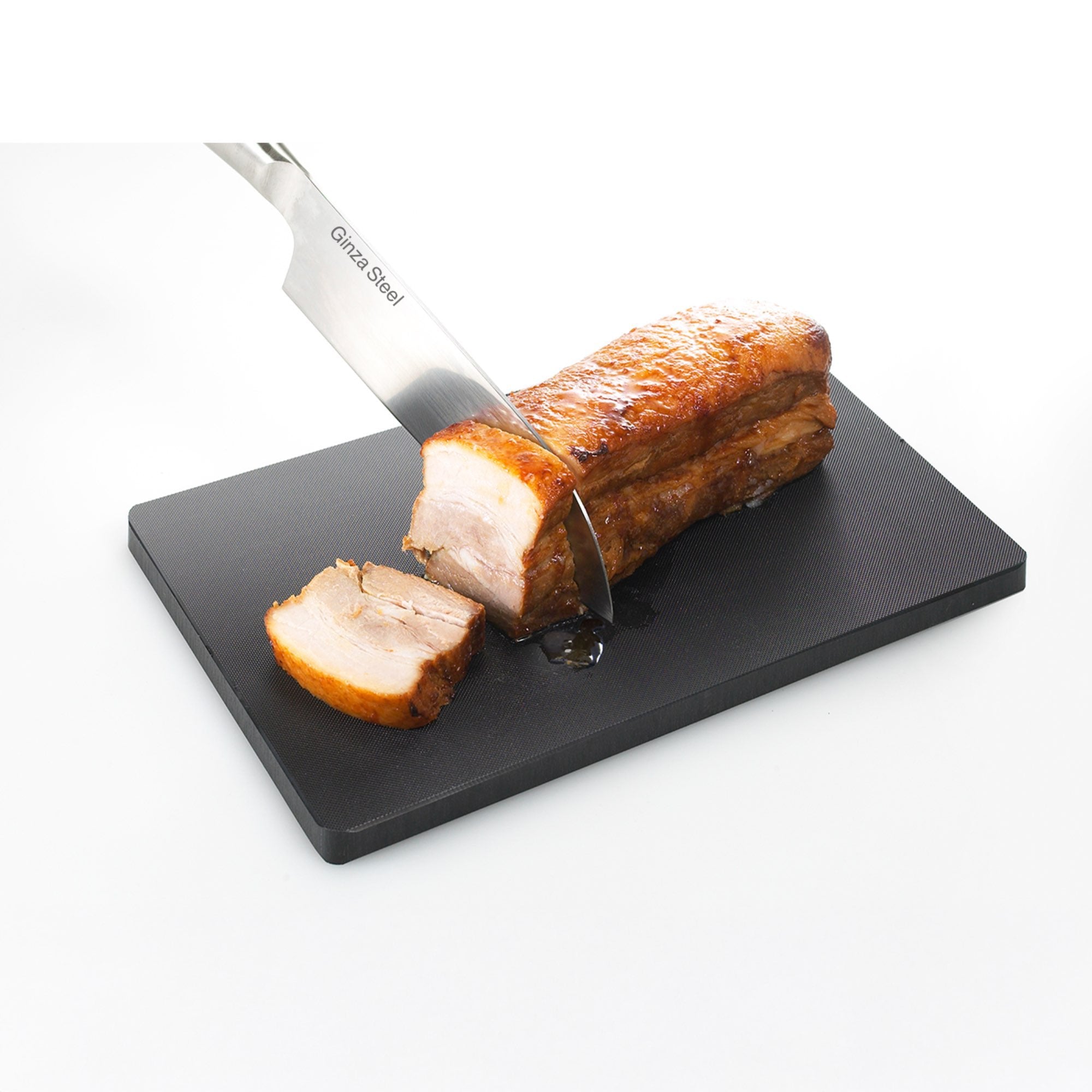 Sliced pork on a black cutting board with a knife, on a white background
