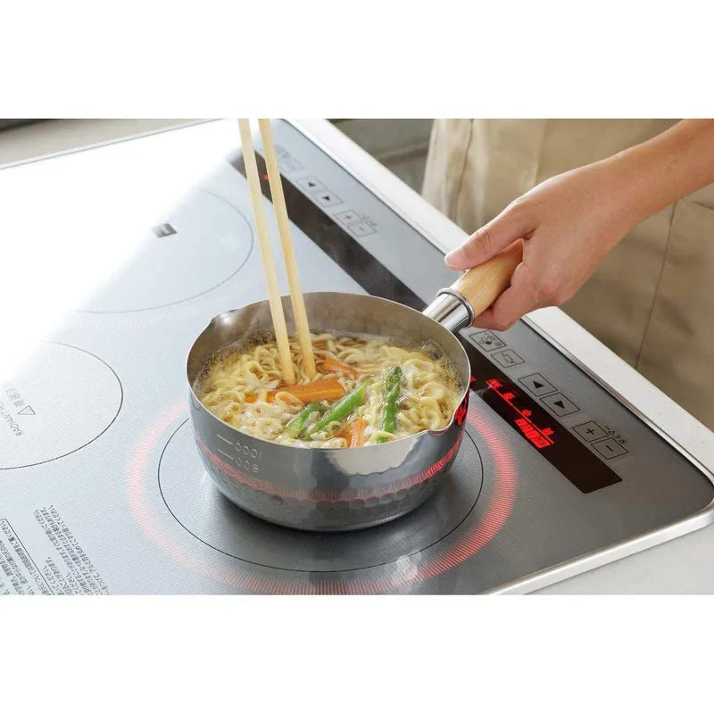 Yoshikawa Yukihira Saucepan with Lid cooking noodles on induction cooktop in a kitchen.