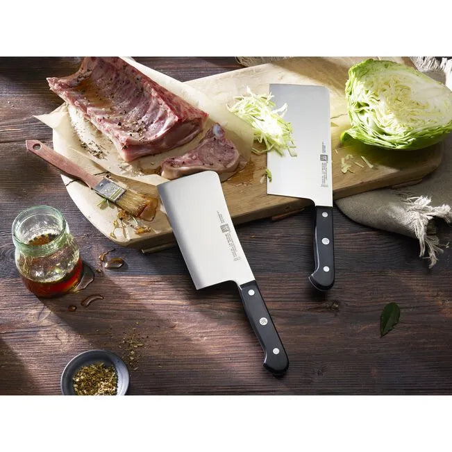 ZWILLING Gourmet Knife Set 2 Piece displayed with meat and vegetables on a wooden cutting board.
