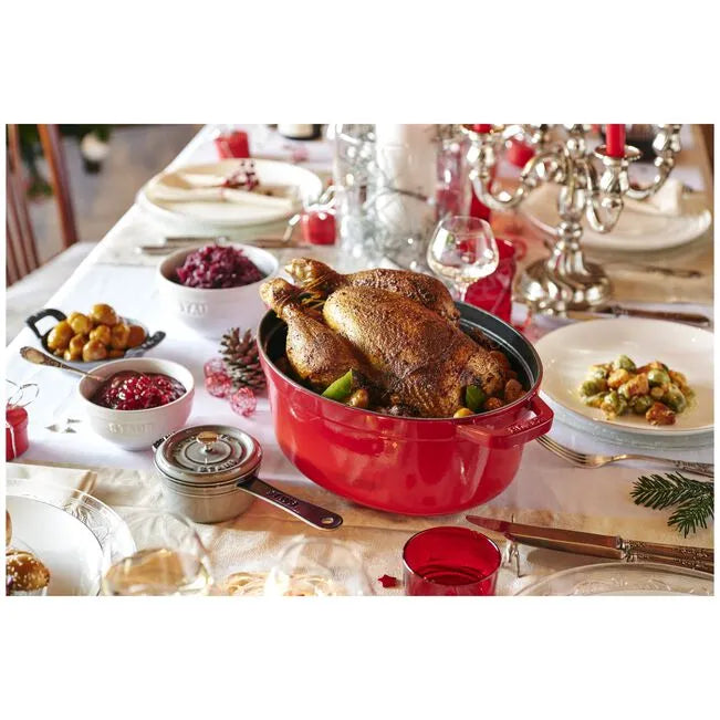 Roasted chicken in a red pot on a festive table with Christmas decorations