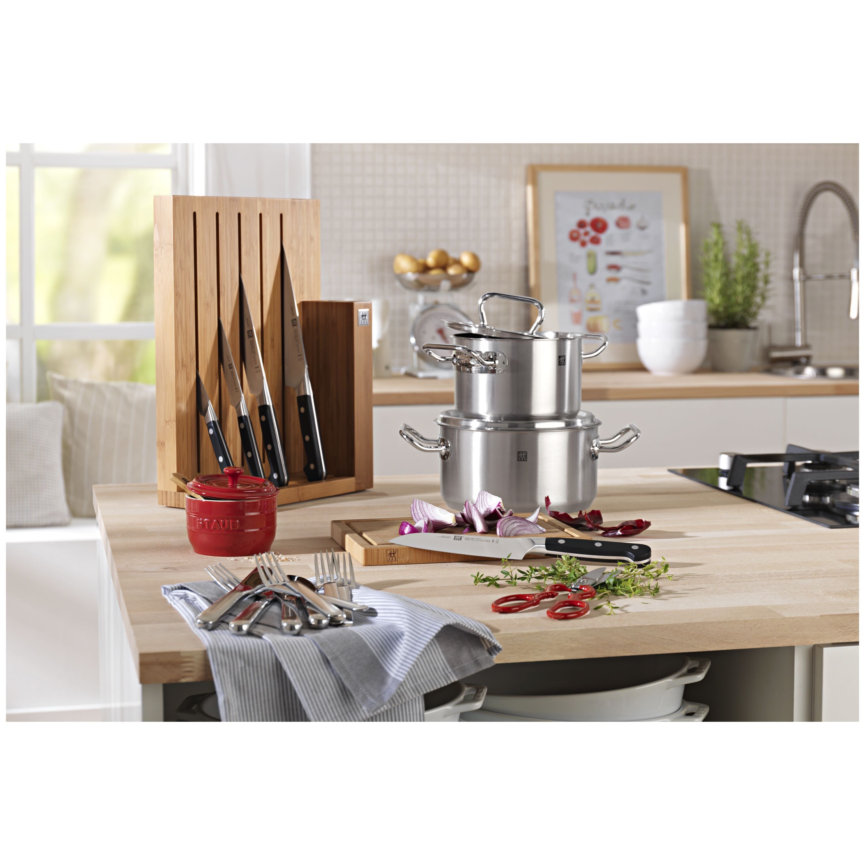 Kitchen setup with STAUB Ceramique Ceramic Salt Crock, pans, and utensils on a wooden countertop.