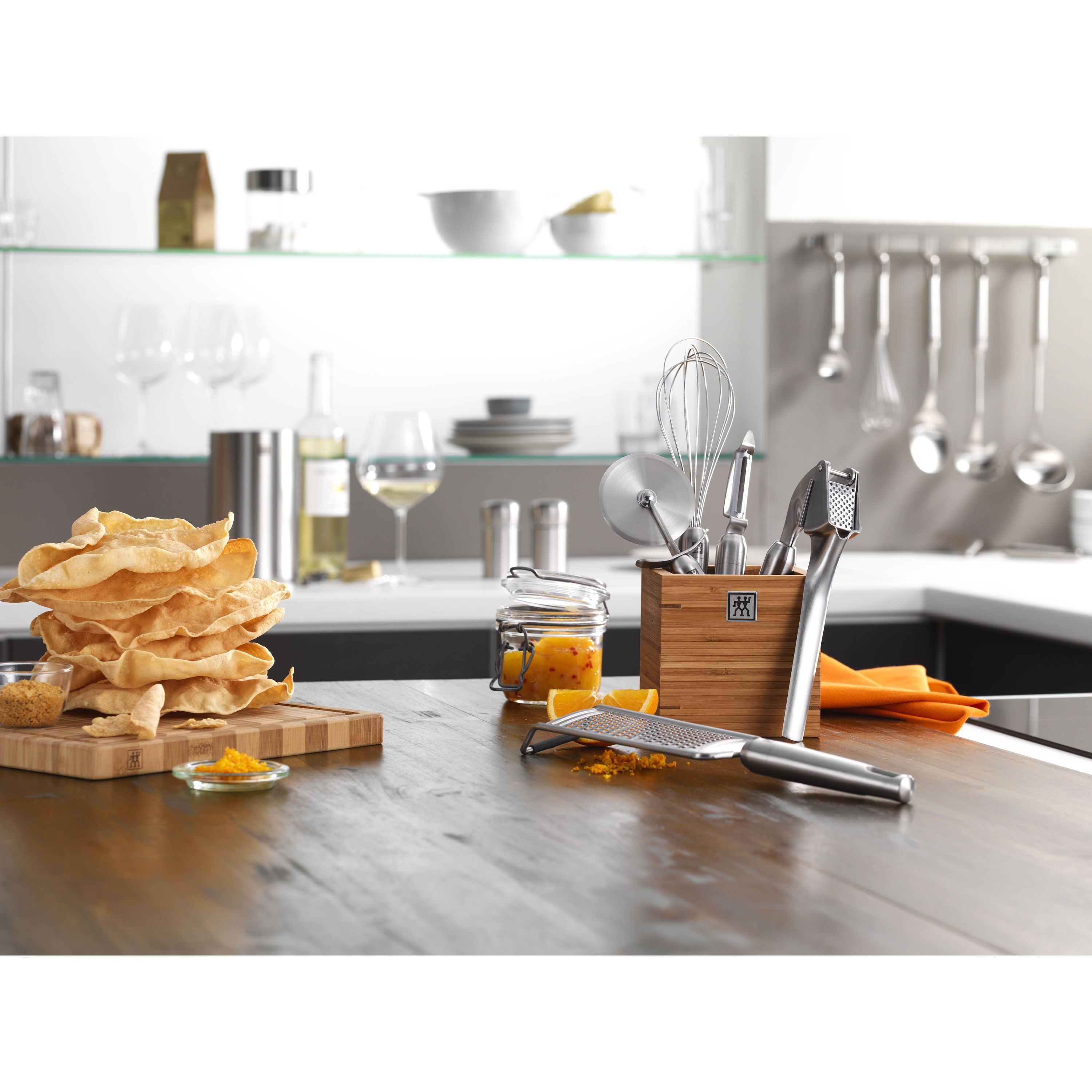 Kitchen counter with utensils, a cutting board, and food items.