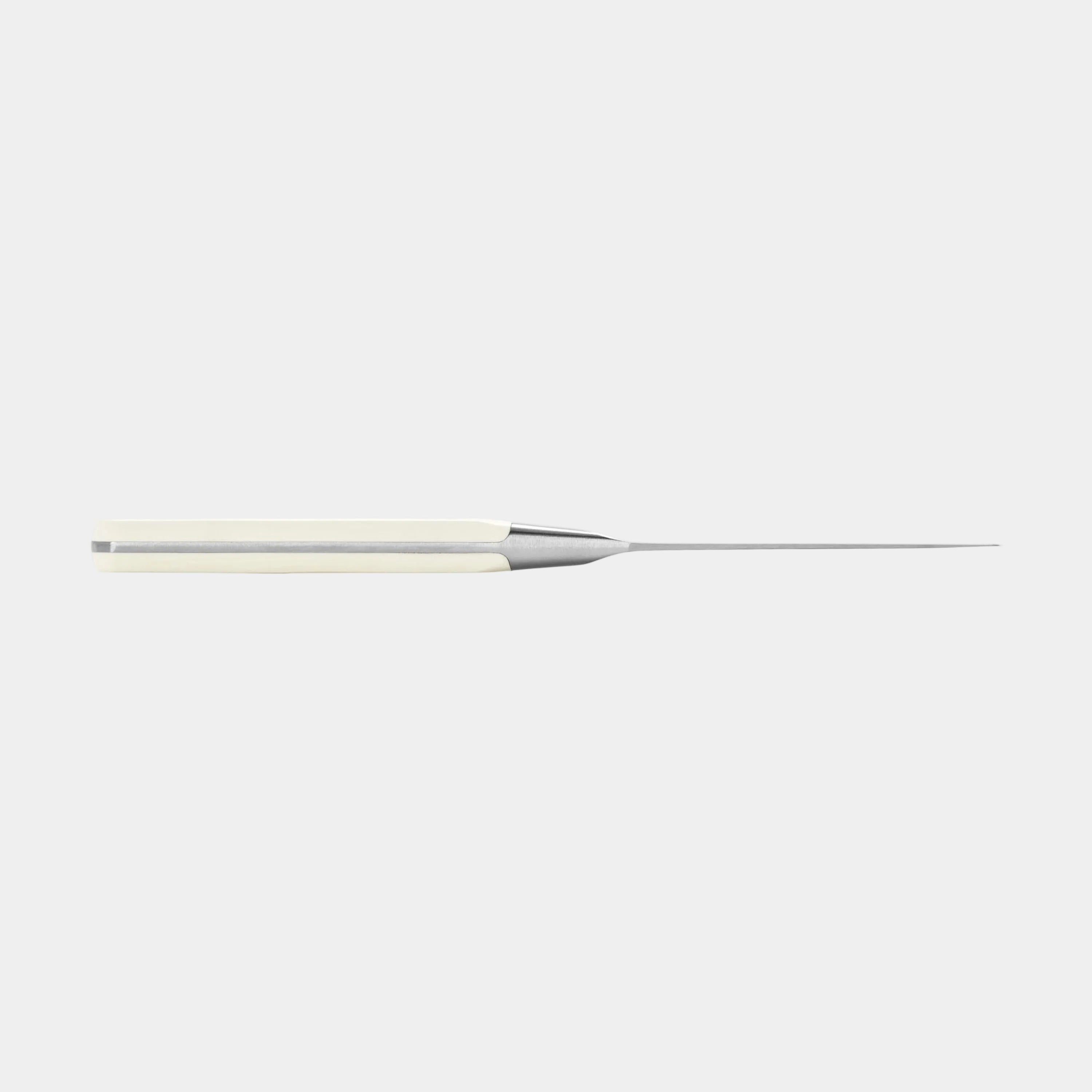 Long thin metallic object on a white background